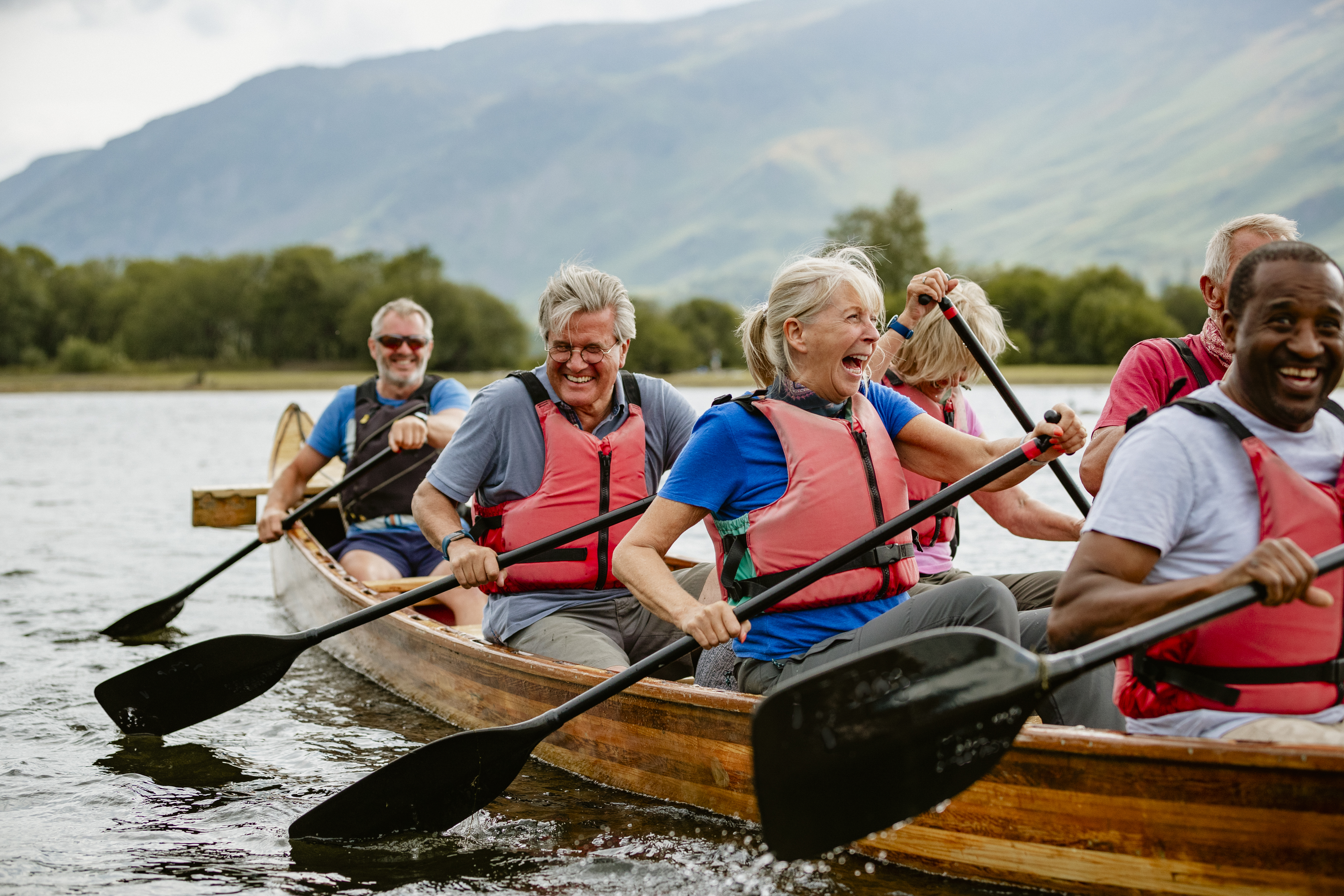 A senior group of tourists enjoying rowing on the River Derwent