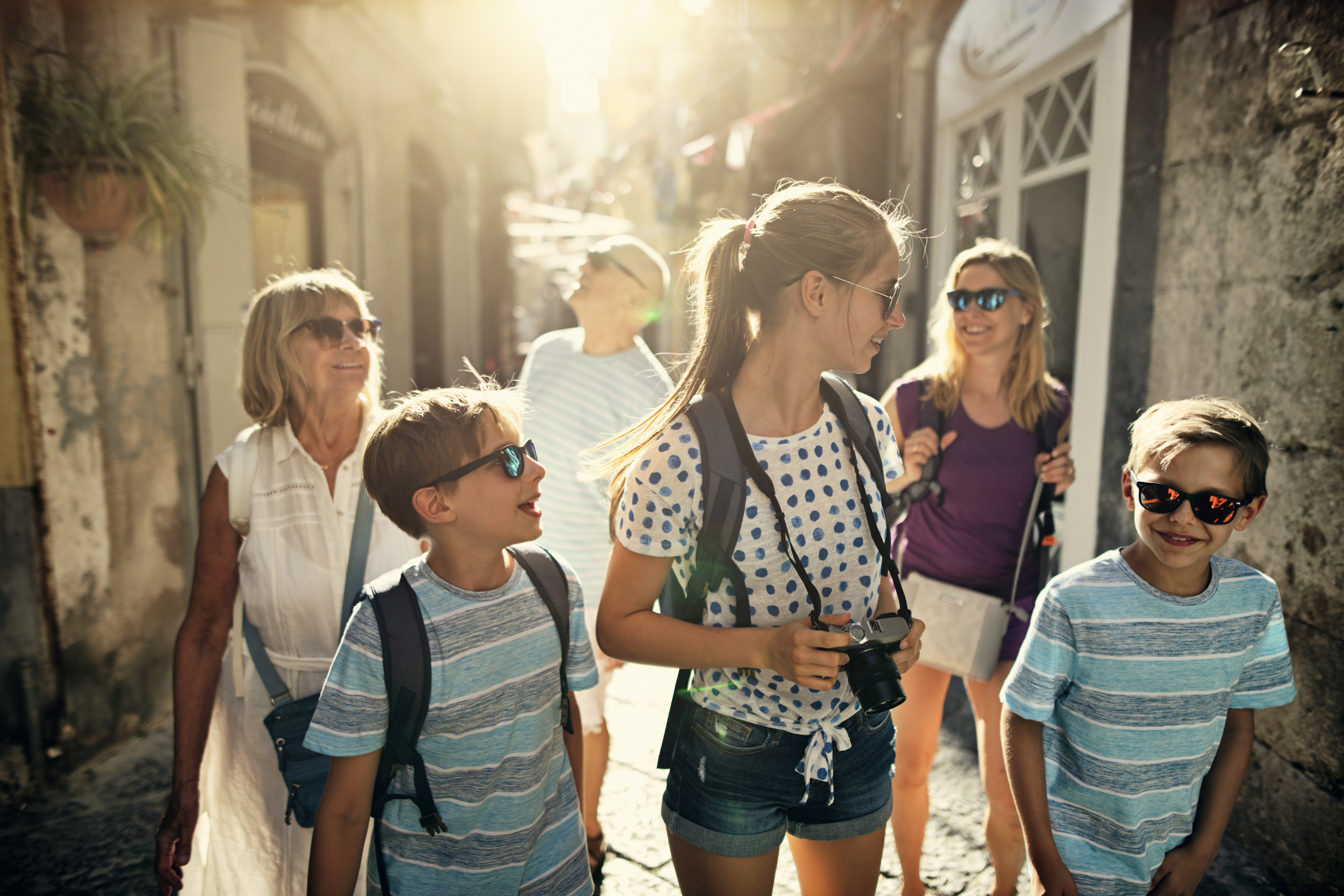 Multi generation family enjoying summer vacations. The family is walking in the narrow streets of an Italian town