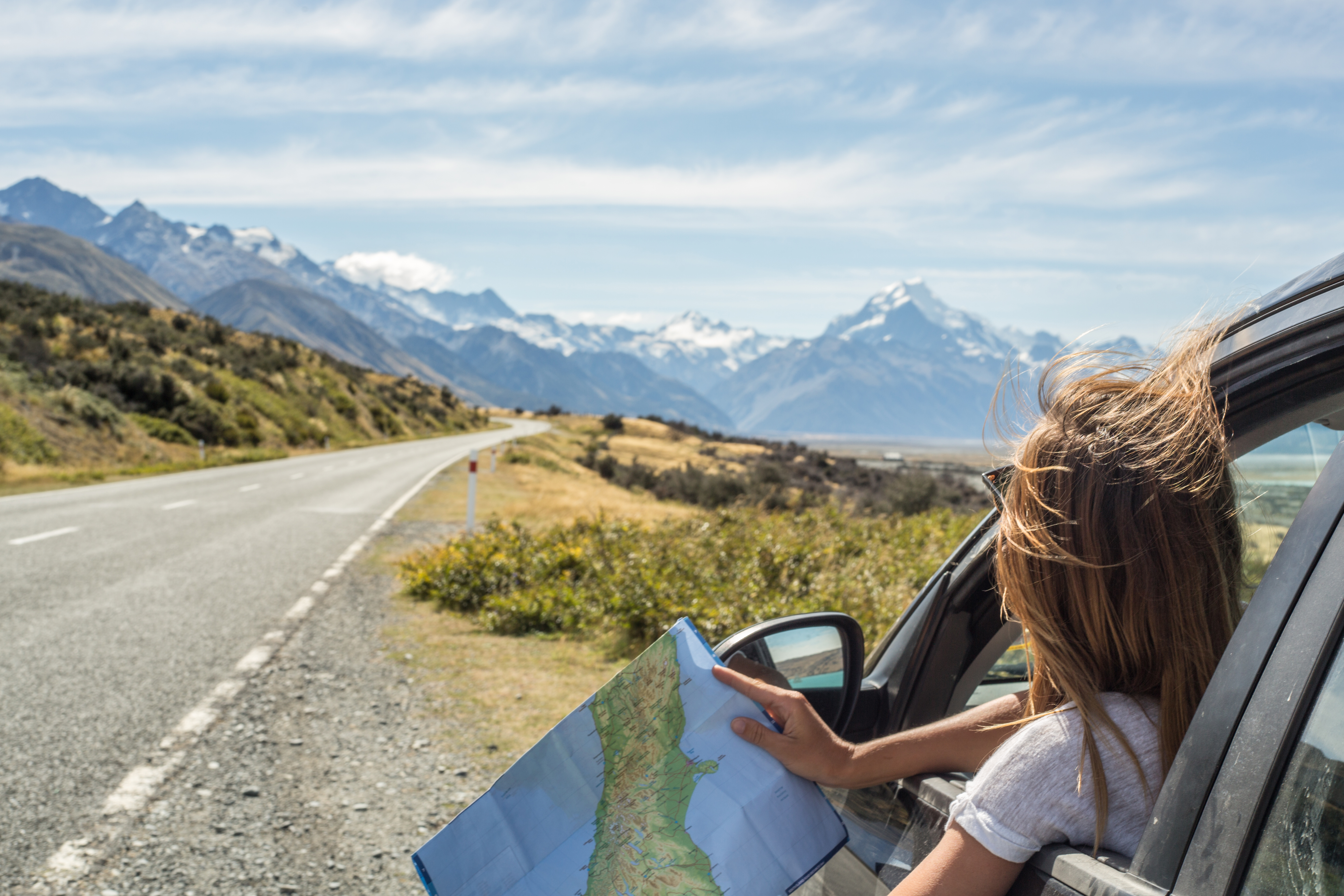 Woman in a car looking at a map for directions