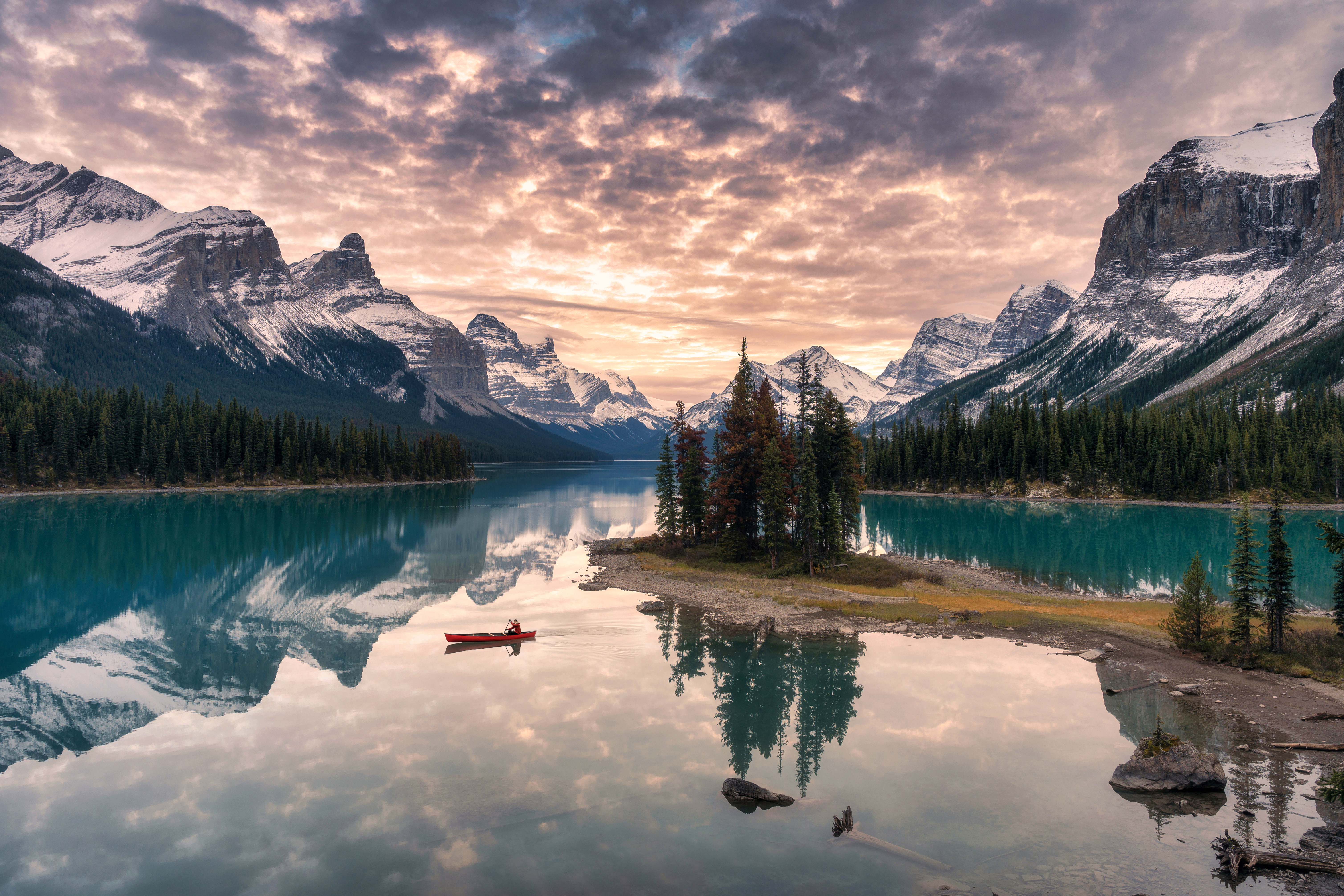 Traveler canoeing with rocky mountain reflection on Maligne lake at Spirit island in Jasper National Park, Canada