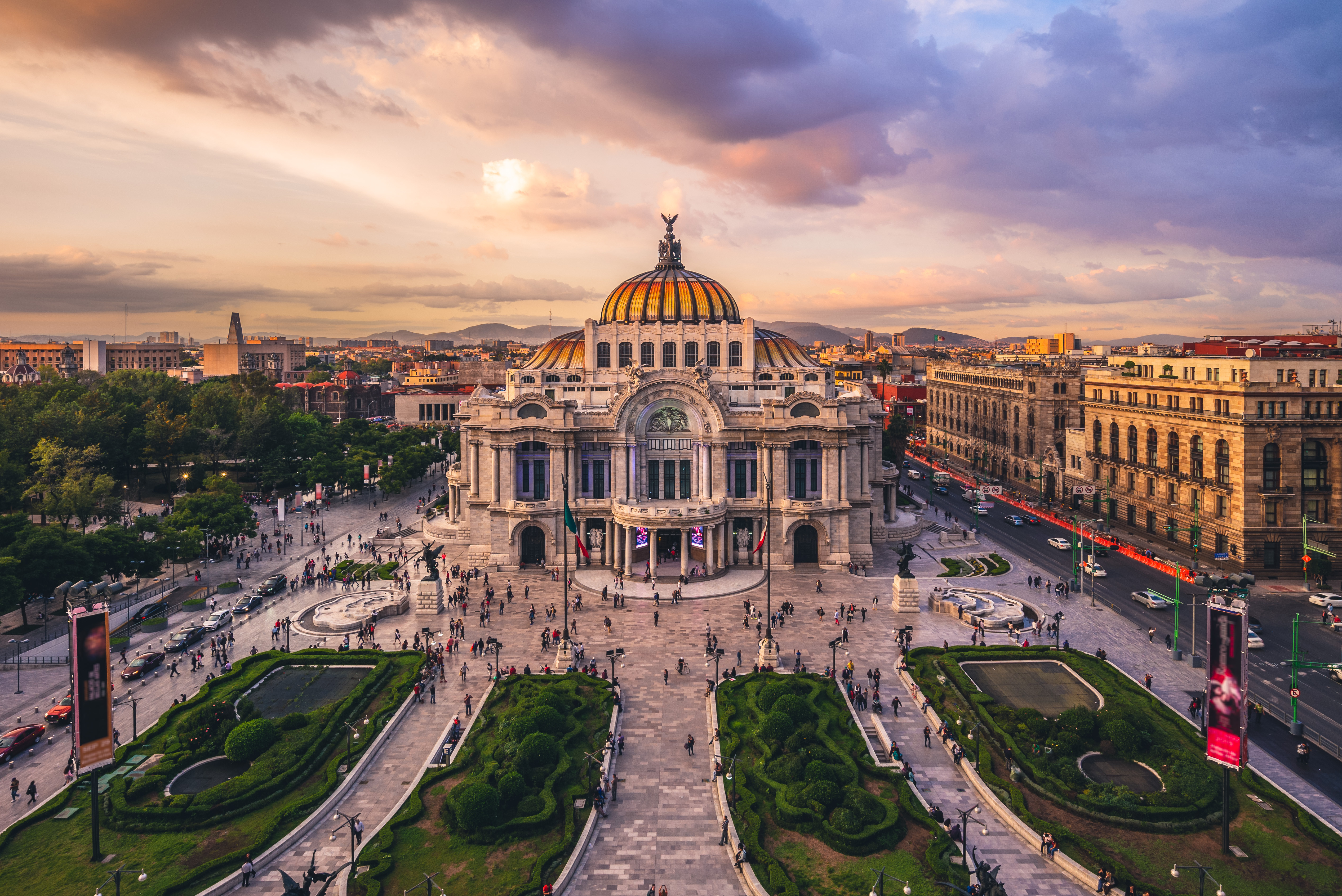 sunset over the Palace of Fine Arts, an impressive dome building in the heart of Mexico City