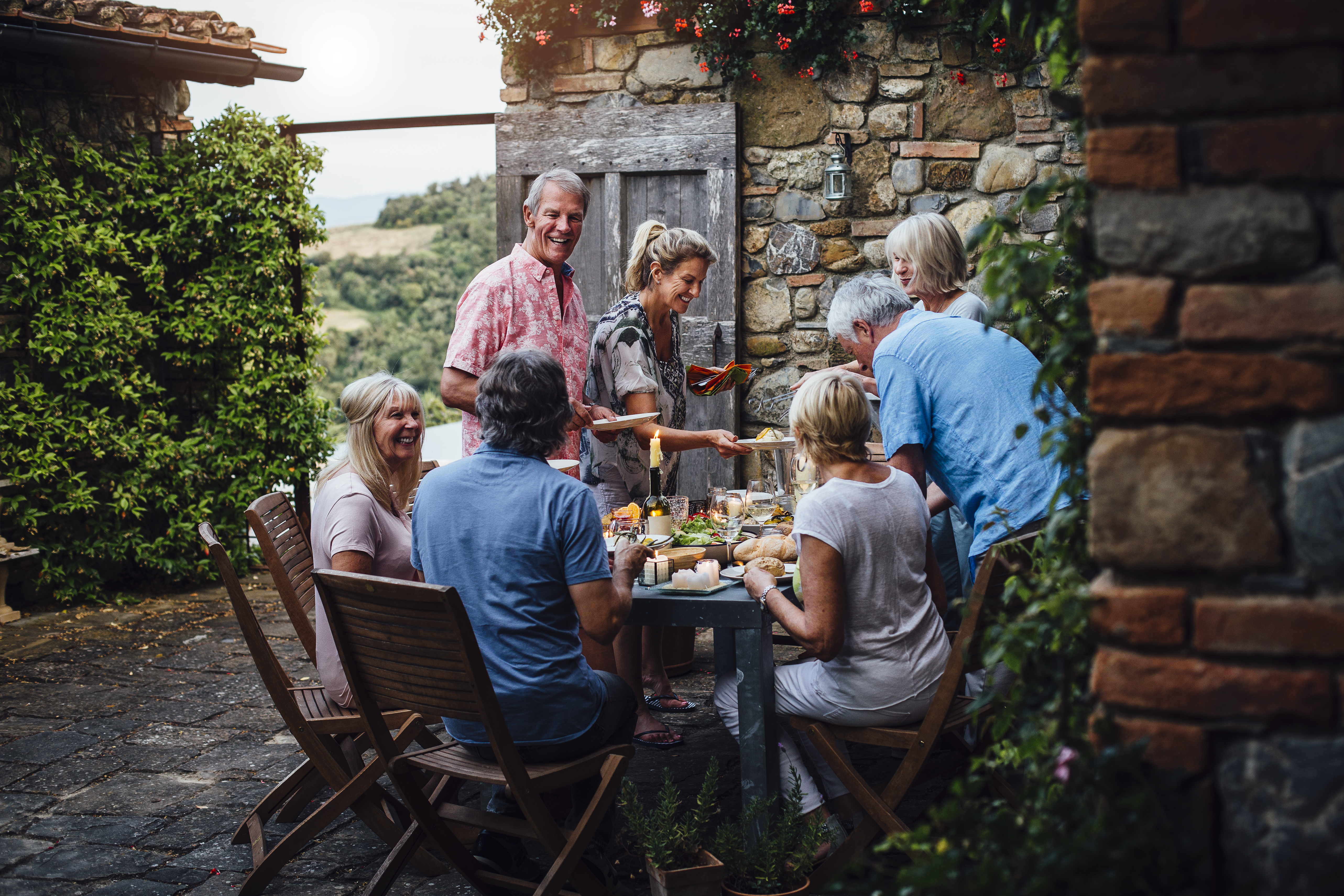 Italy A group of people eat dinner at an outdoor dining table in Italy.