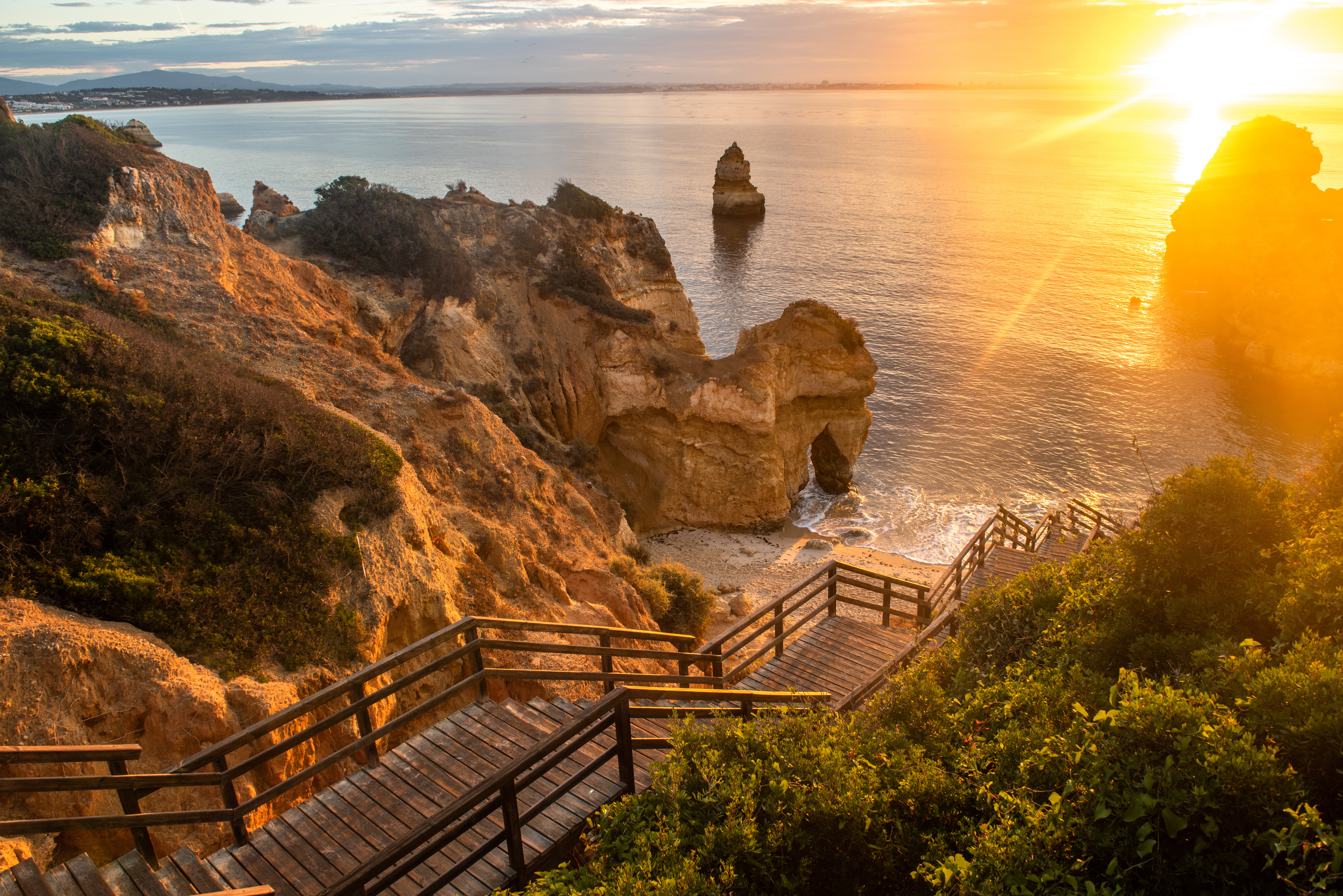 Wooden footbridge to beautiful beach Praia do Camilo near Lagos in Portugal at sunrise