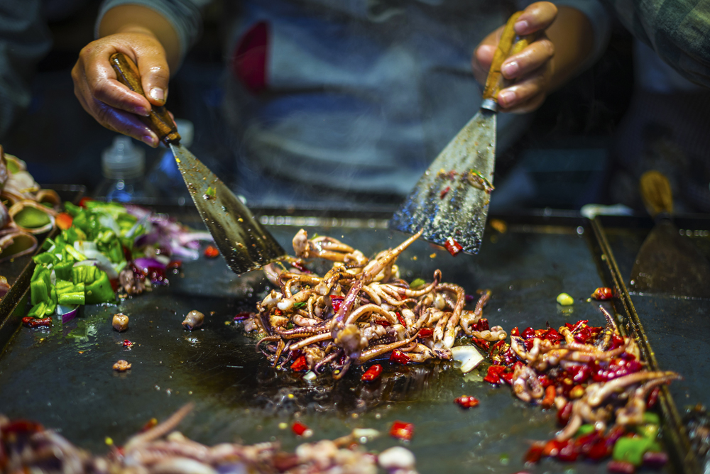 Chef making iron squid in old town of Lijiang, Yunnan Province, China Holidays