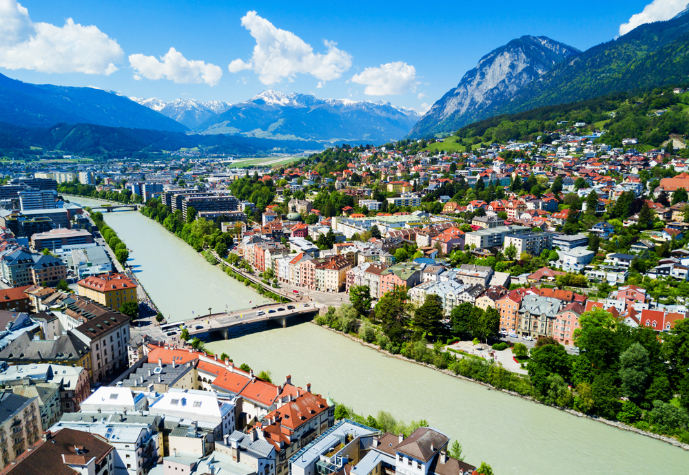 view of river through town with mountain backdrop