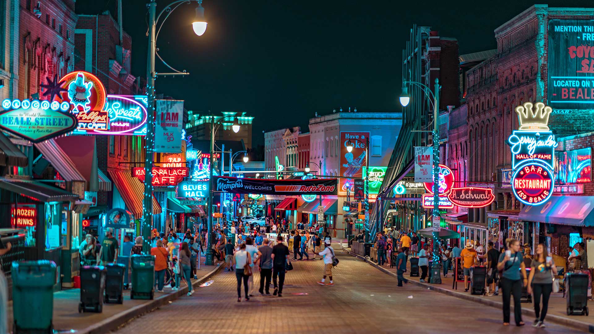 colourful street with people and bars and neon signs