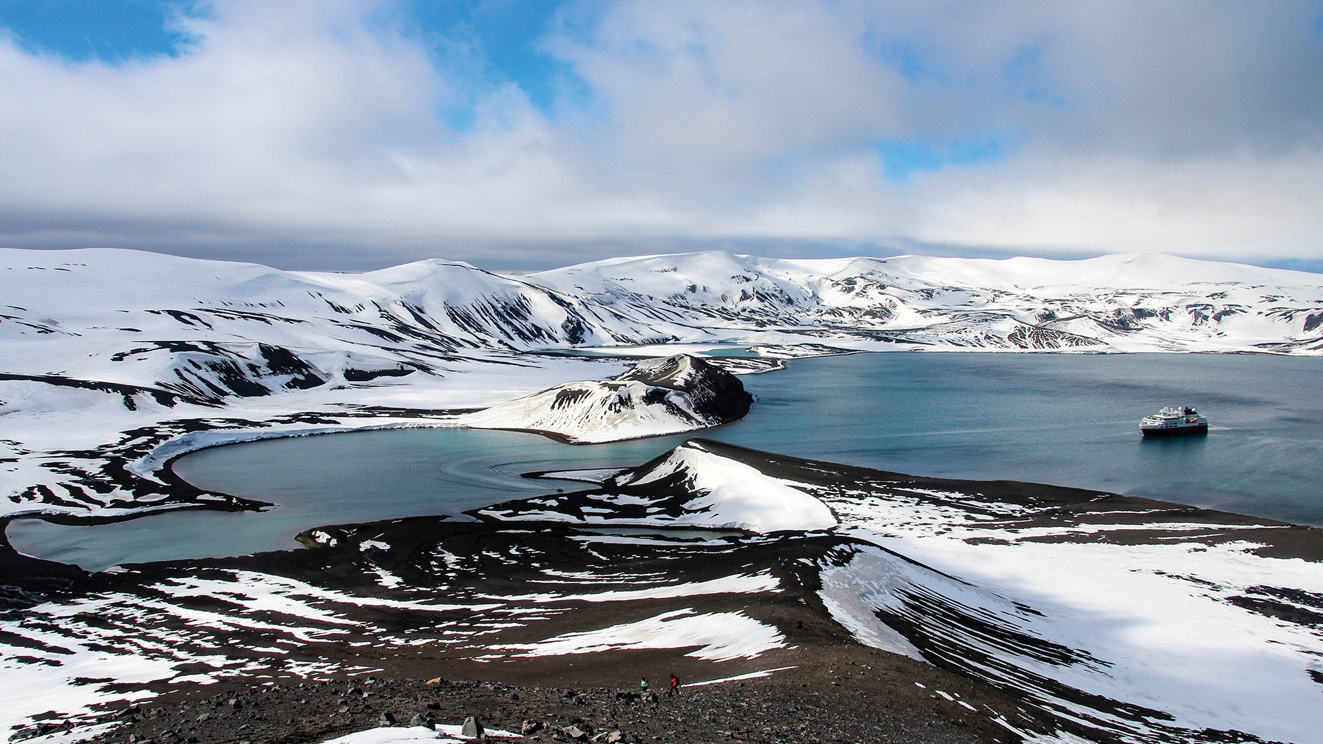 An overhead shot of a boat sailing through the Antarctica Peninsula