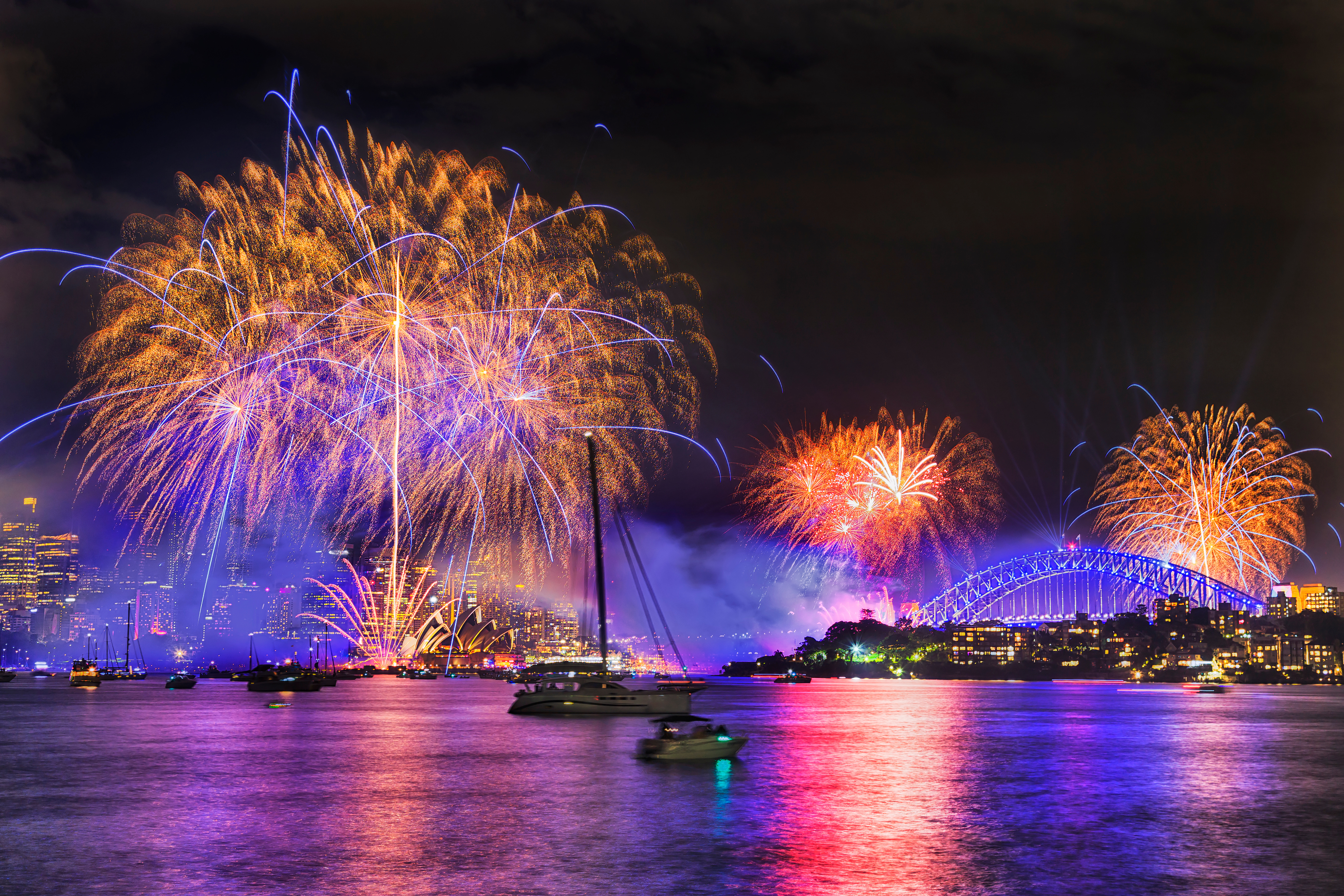 fireworks display over a harbour at night