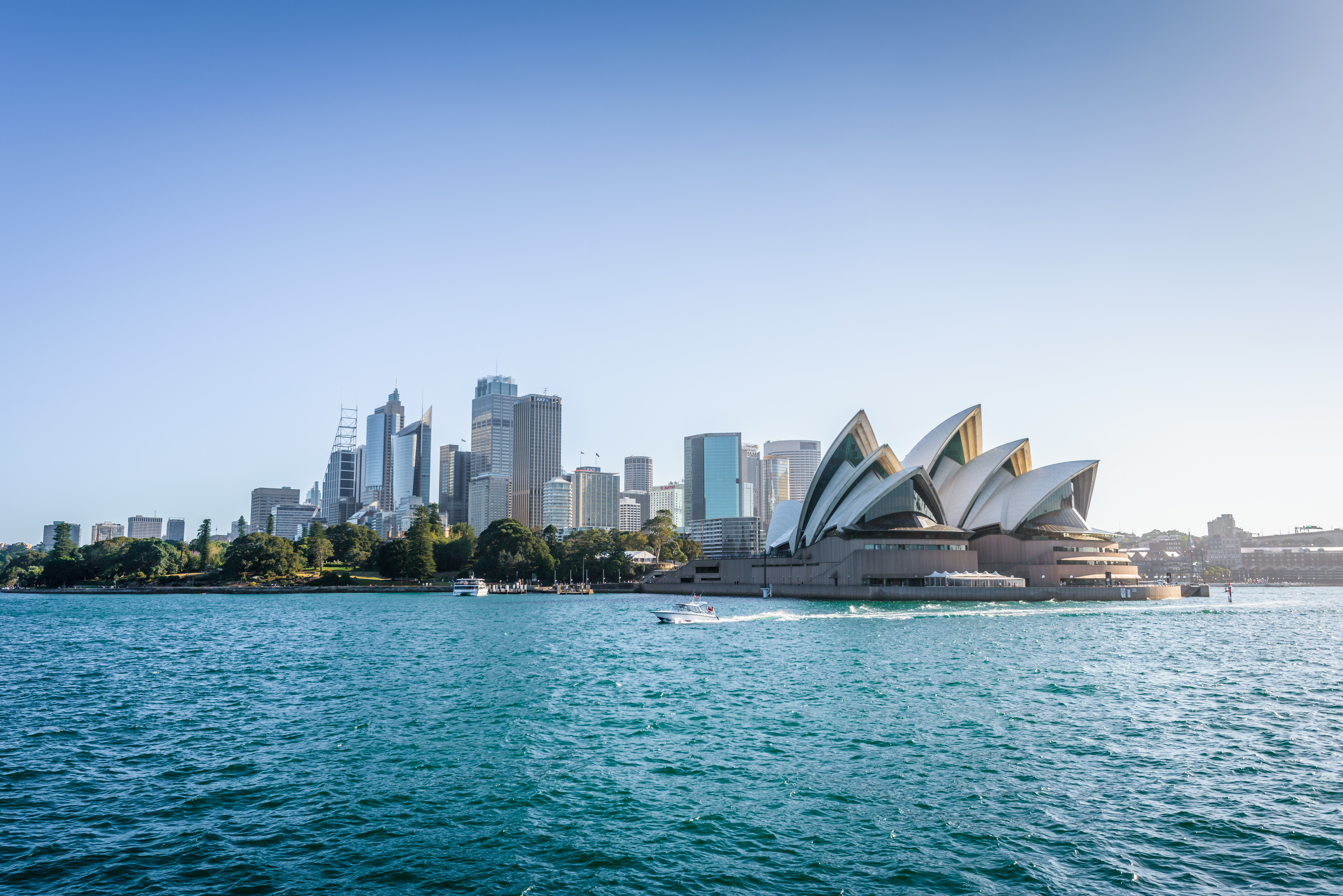view of opera house and buildings in harbour with blue sky