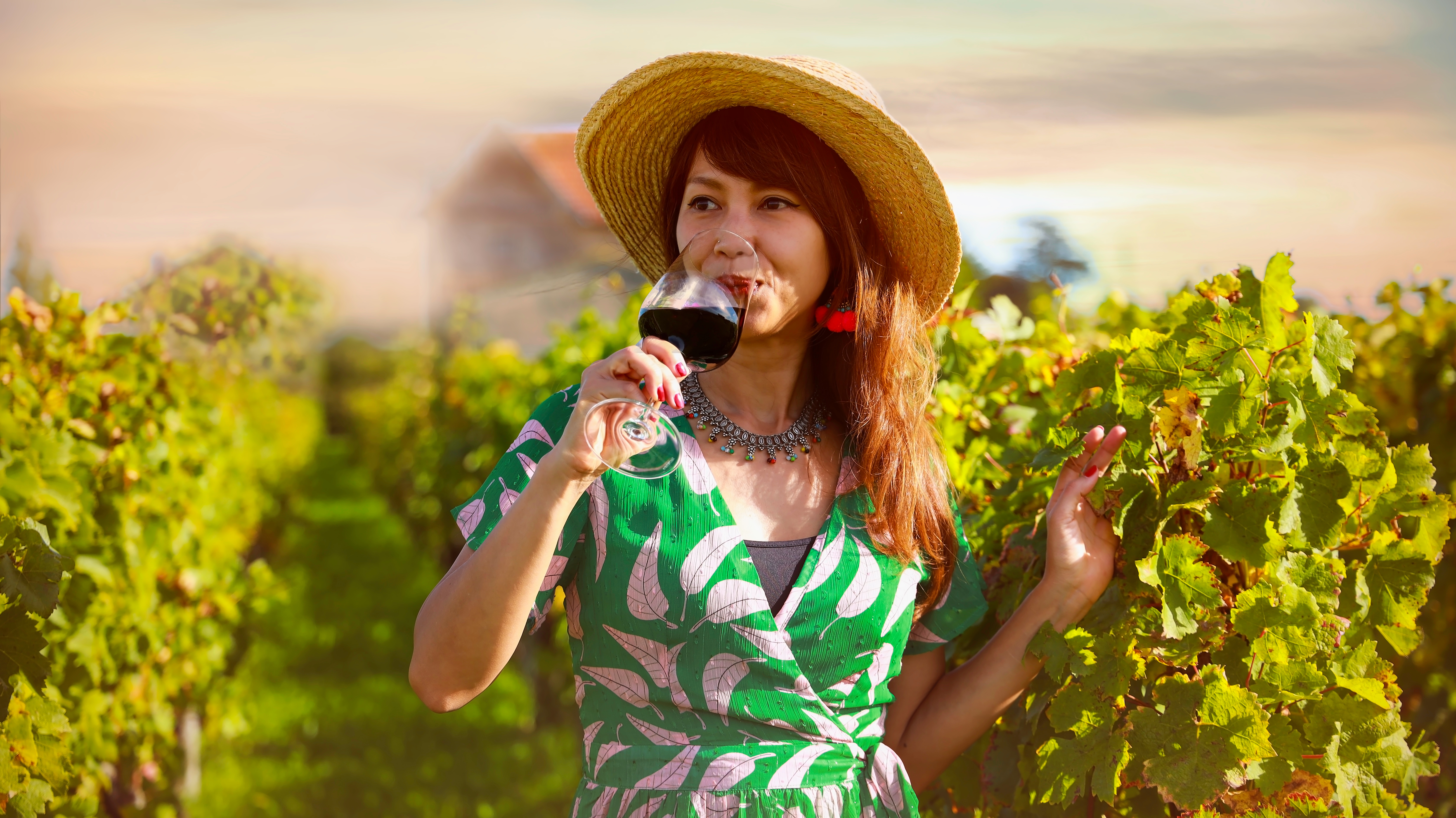 woman in vineyard drinking some wine
