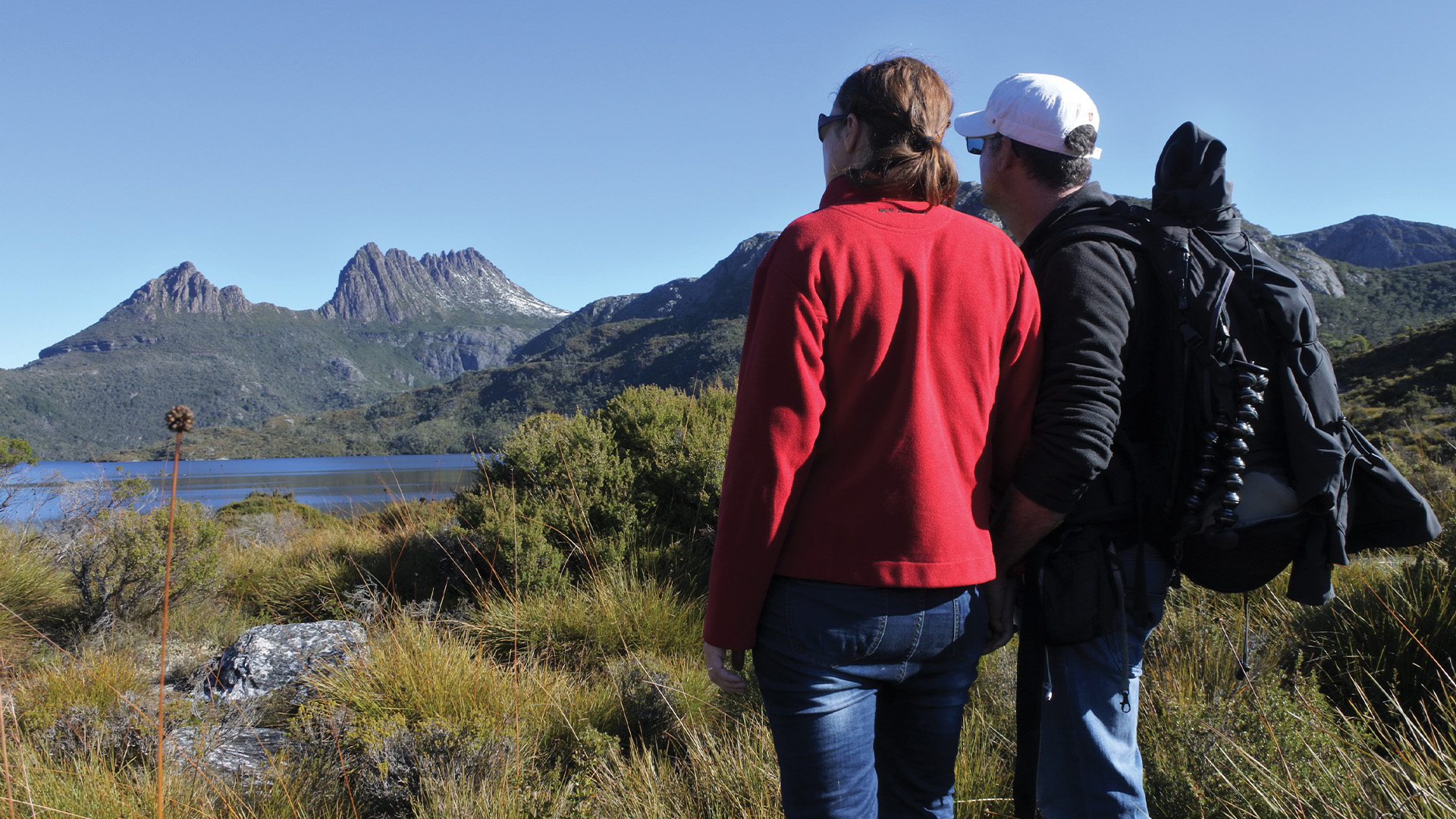 couple looking at green hills on hiking trail
