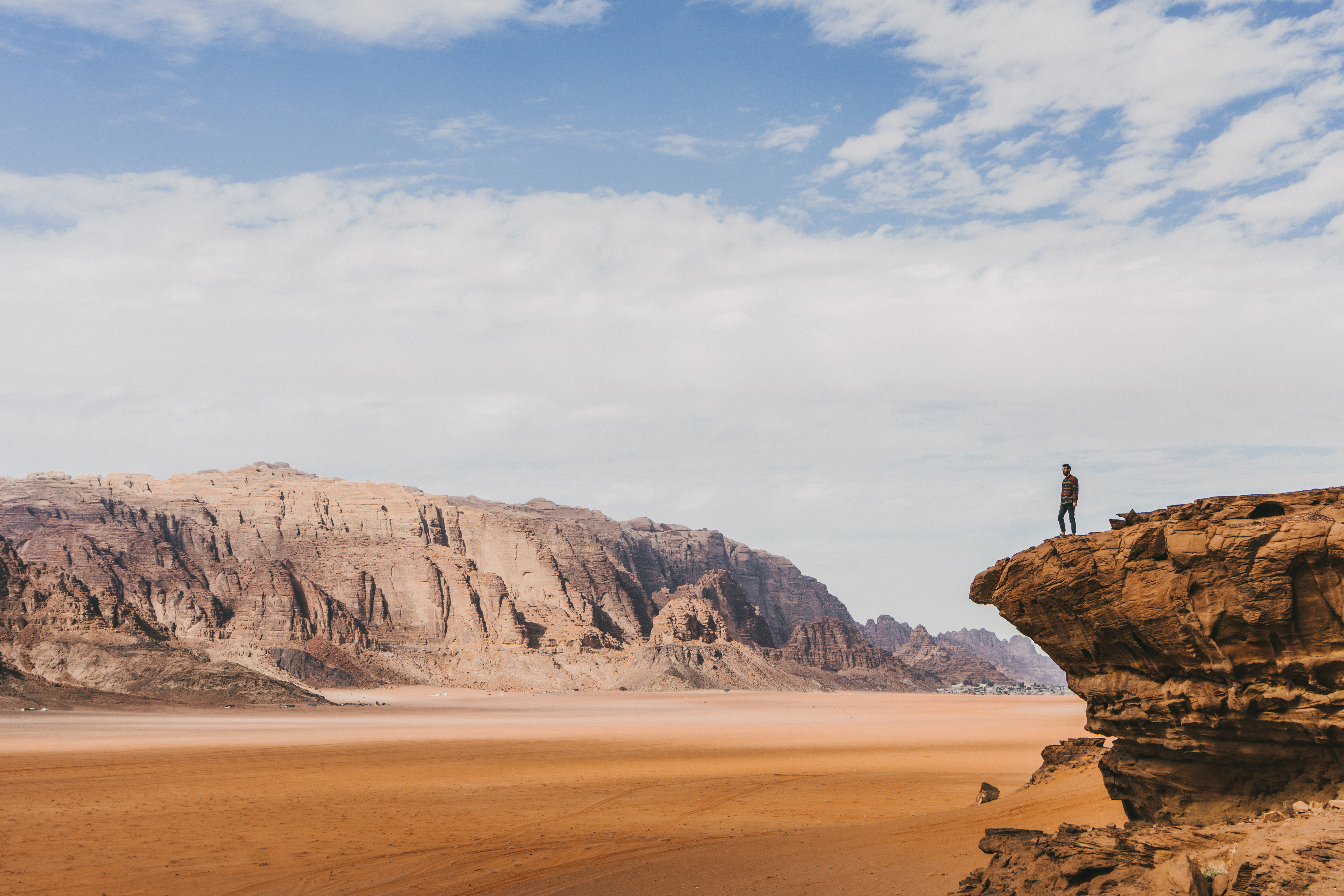 Young Caucasian woman looking at Wadi Rum desert from above at sunset