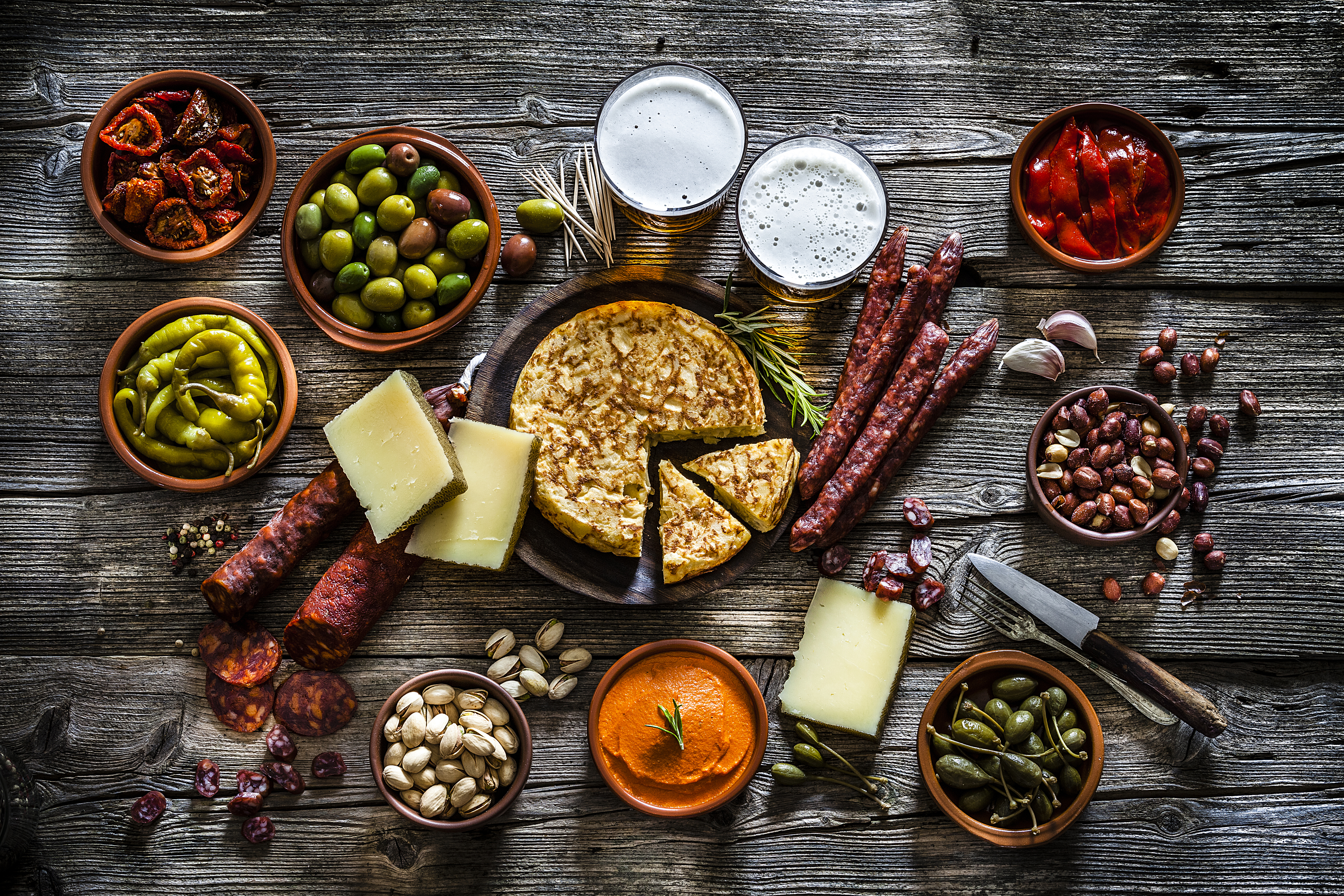 Tapas and beer: typical spanish food shot from above on rustic wooden table 