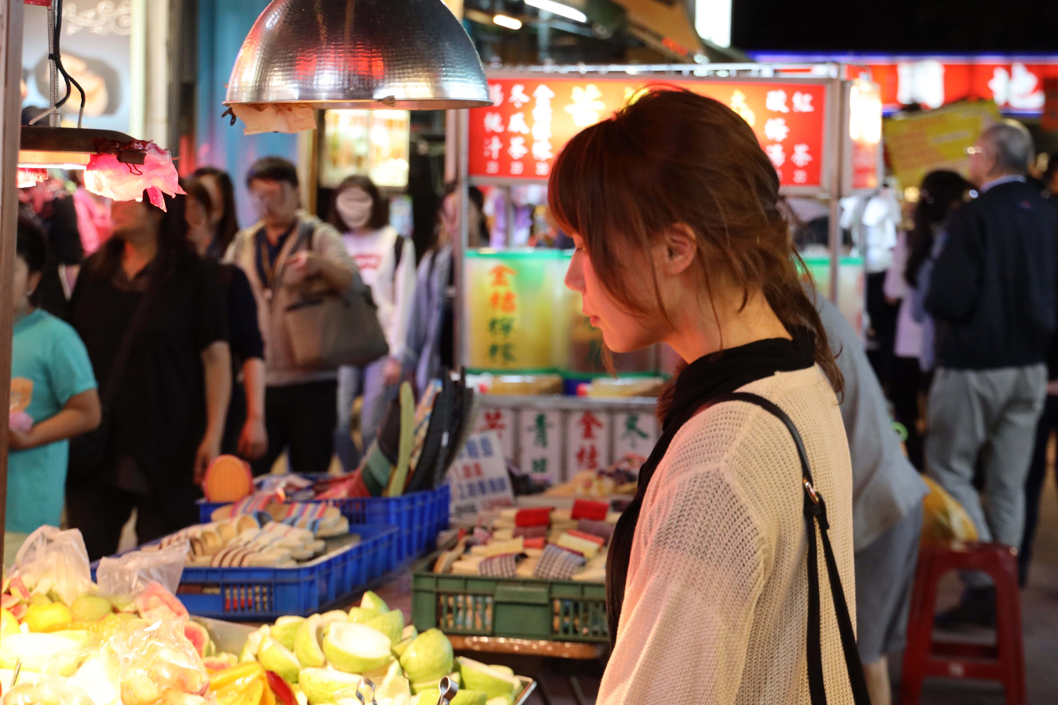 Young woman walking at night market 