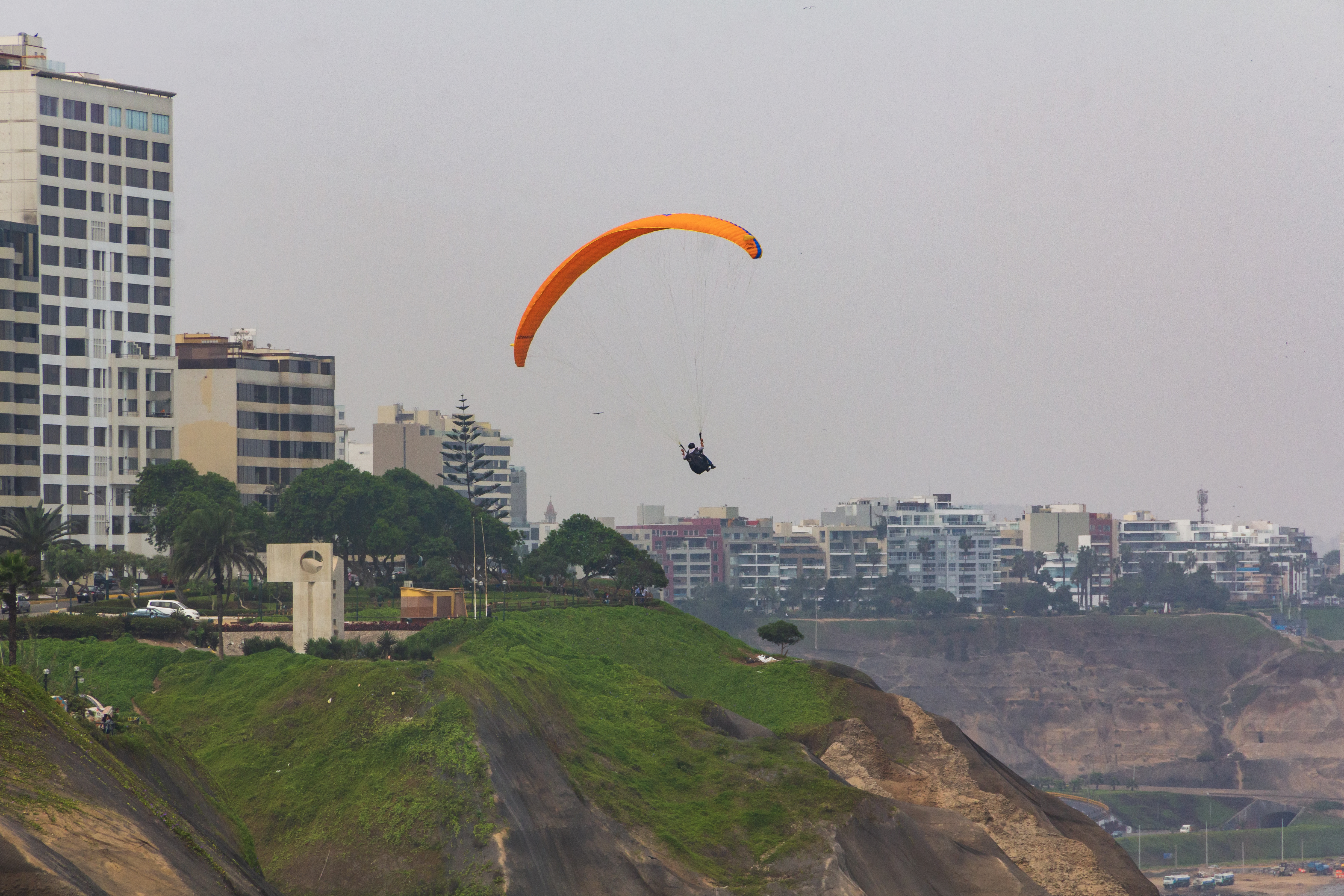 Paragliders sail over the Pacific Ocean off the cliffs of Miraflores.