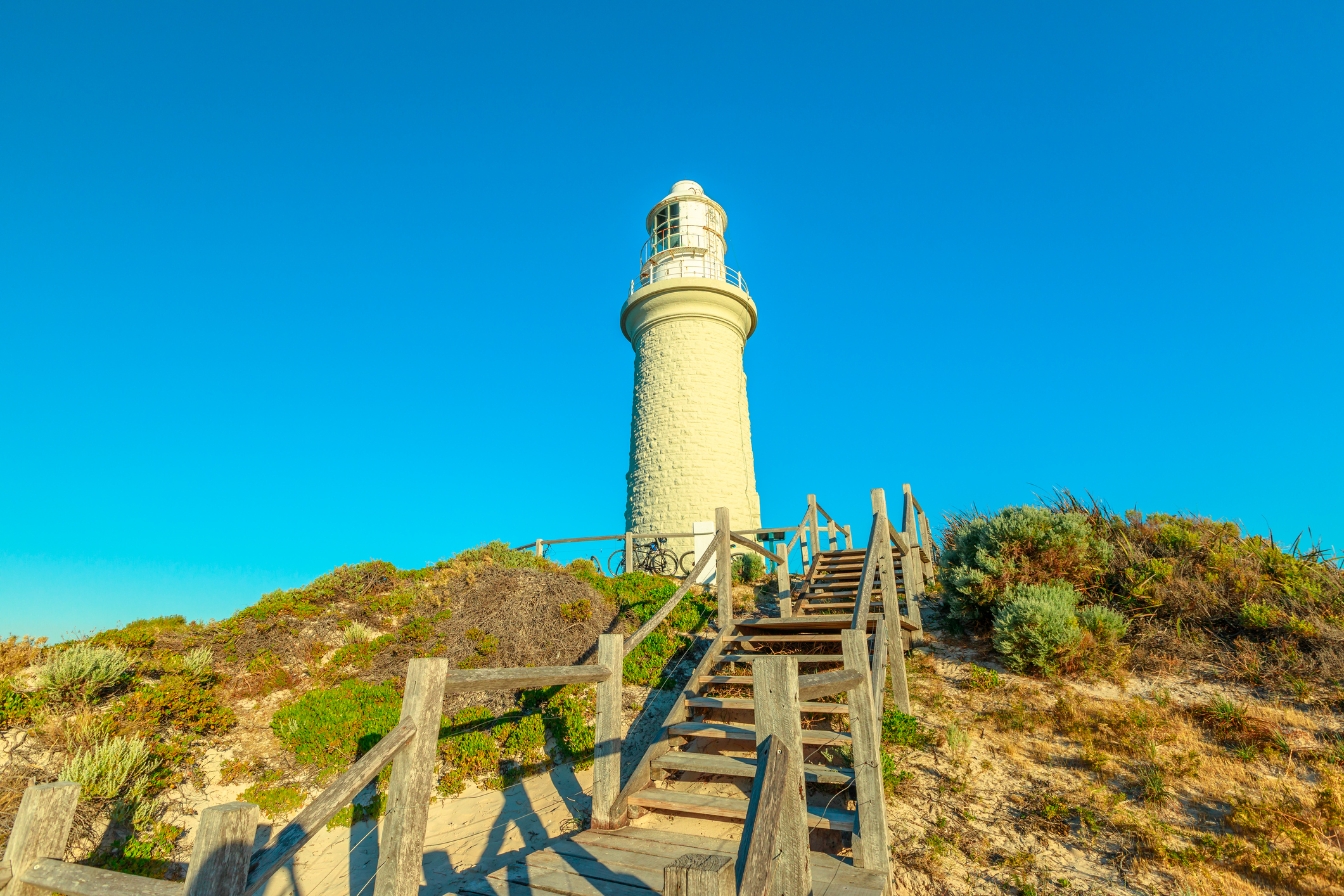 Stairs leading up to Bathurst Lighthouse in north coast of Rottnest Island, near Perth, Western Australia. Sunny afternoon with blue sky.