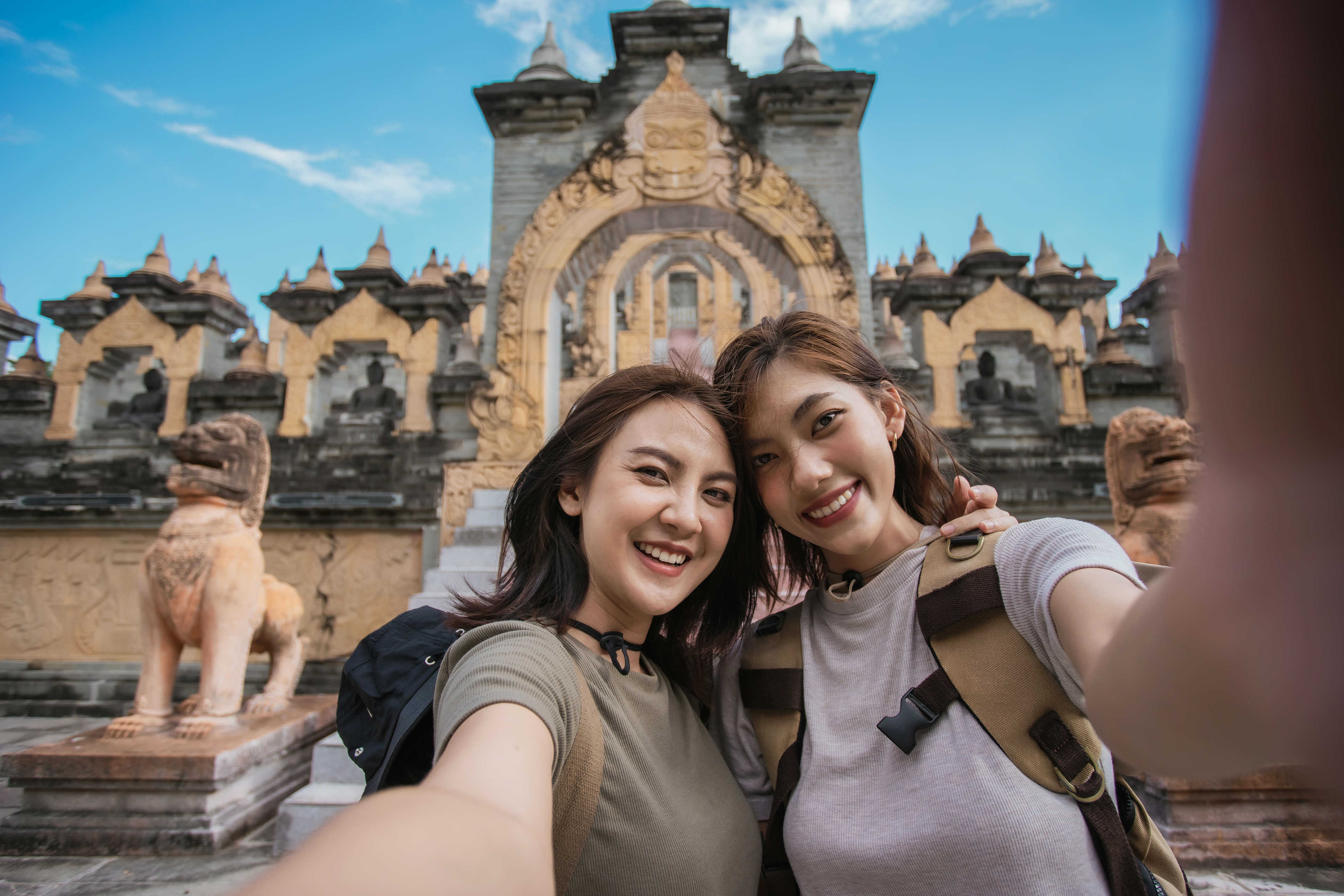 Two Asian woman traveler smile take a photo selfie together with pagoda of buddhist temple in background. Travel pagoda of buddhist in Asia.