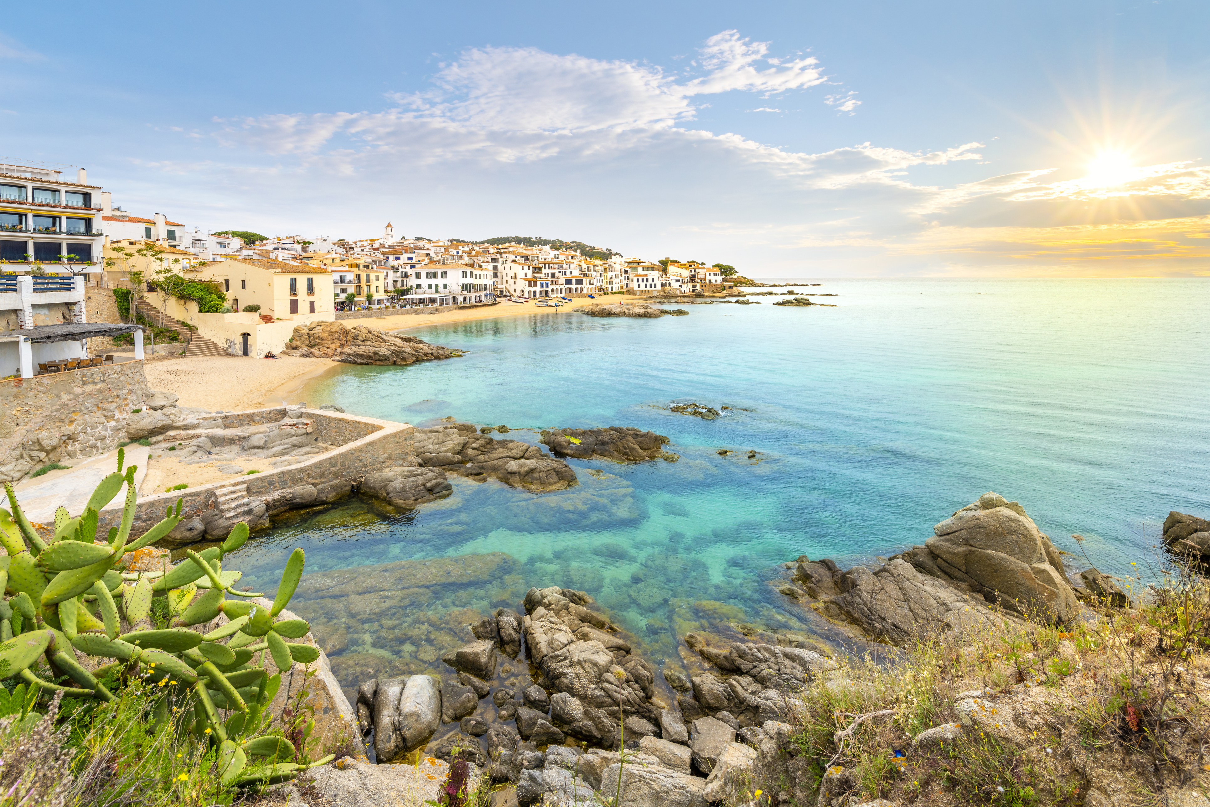 View of the sandy beach, rocky coastline and whitewashed town