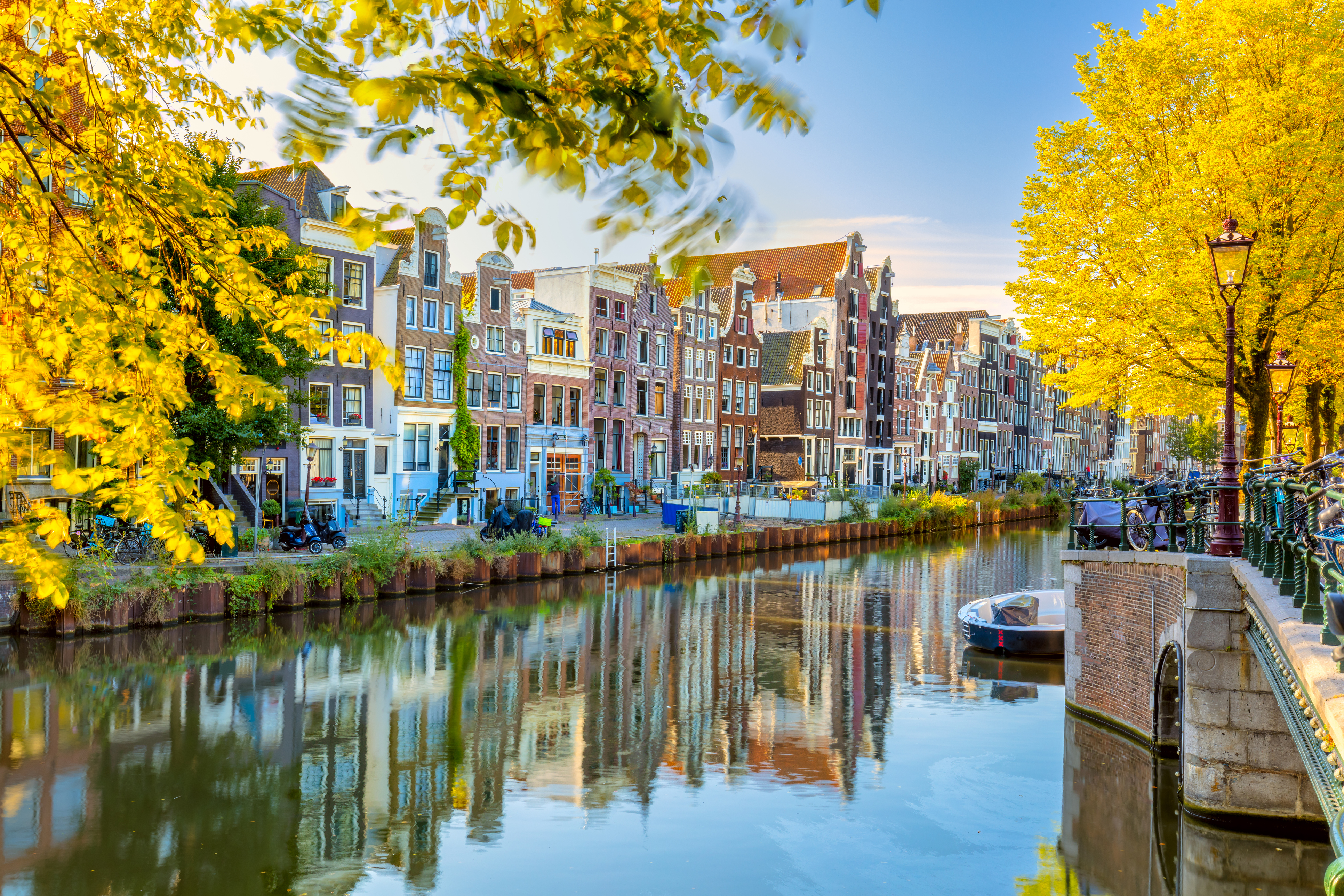 Autumn morning in Amsterdam. Silence. Ancient houses are reflected in the water of the canal, the sun shines through the trees. Lovely morning in Amsterdam