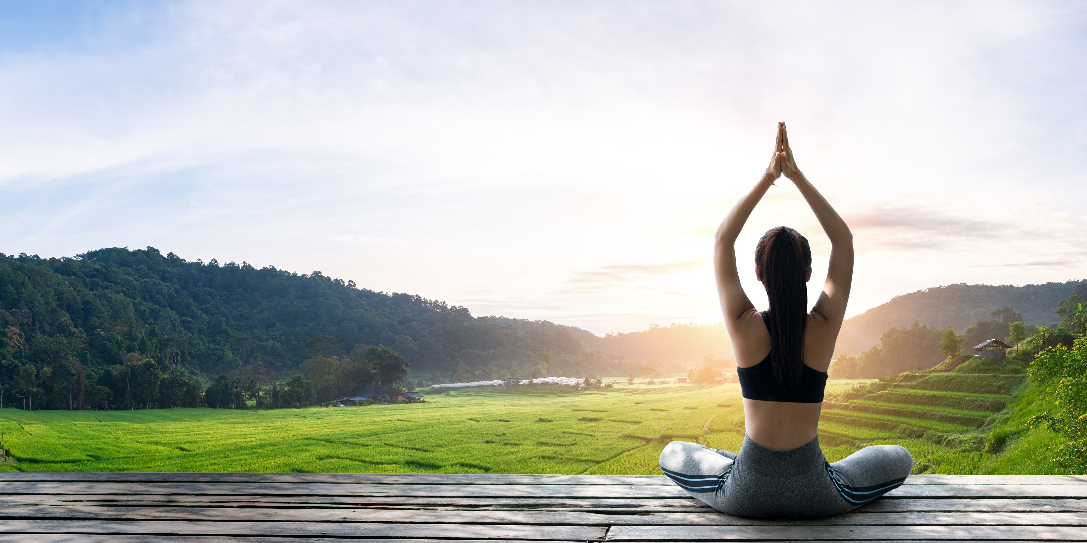 Asian woman doing yoga on the wooden balcony