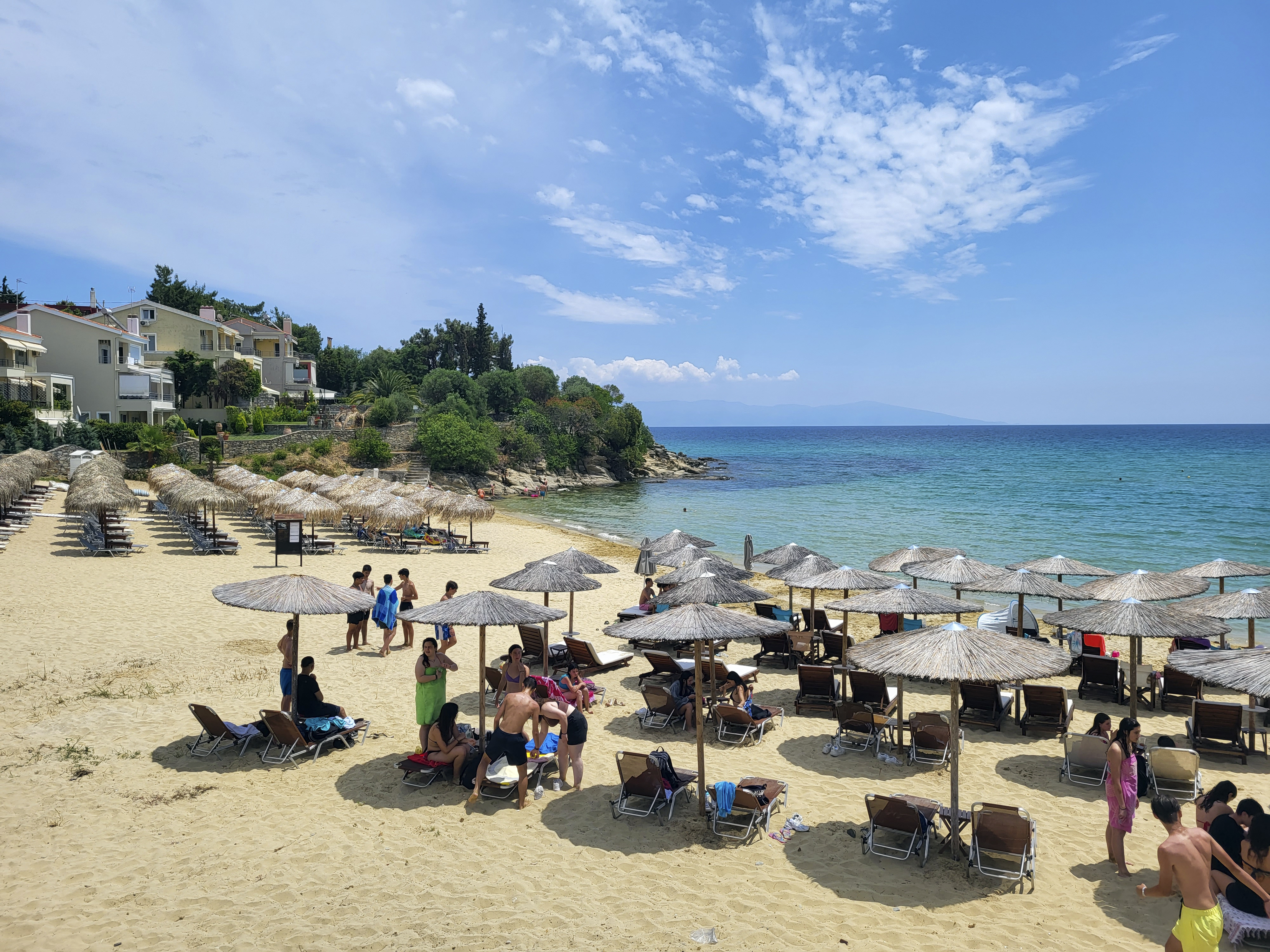 people enjoy a sunny sommer day on the sandy beach on Aegean sea
