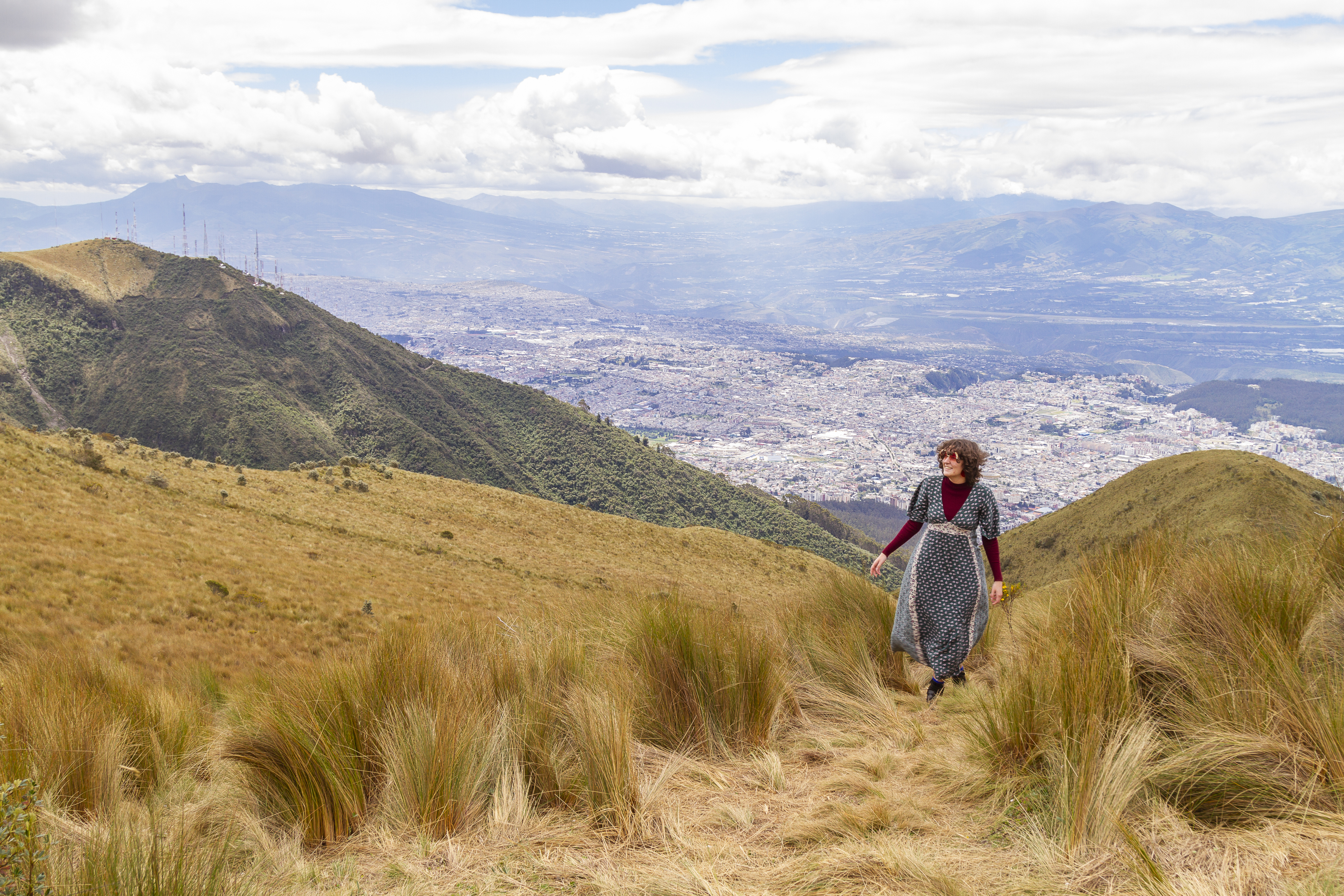 Portrait of young teenager solo traveler female walking to the top of the Pichincha's volcano mountain. On Back, the ecuatorian capital: Quito. Carefree backpacker fashion woman, in Quito, Pichincha, Ecuador