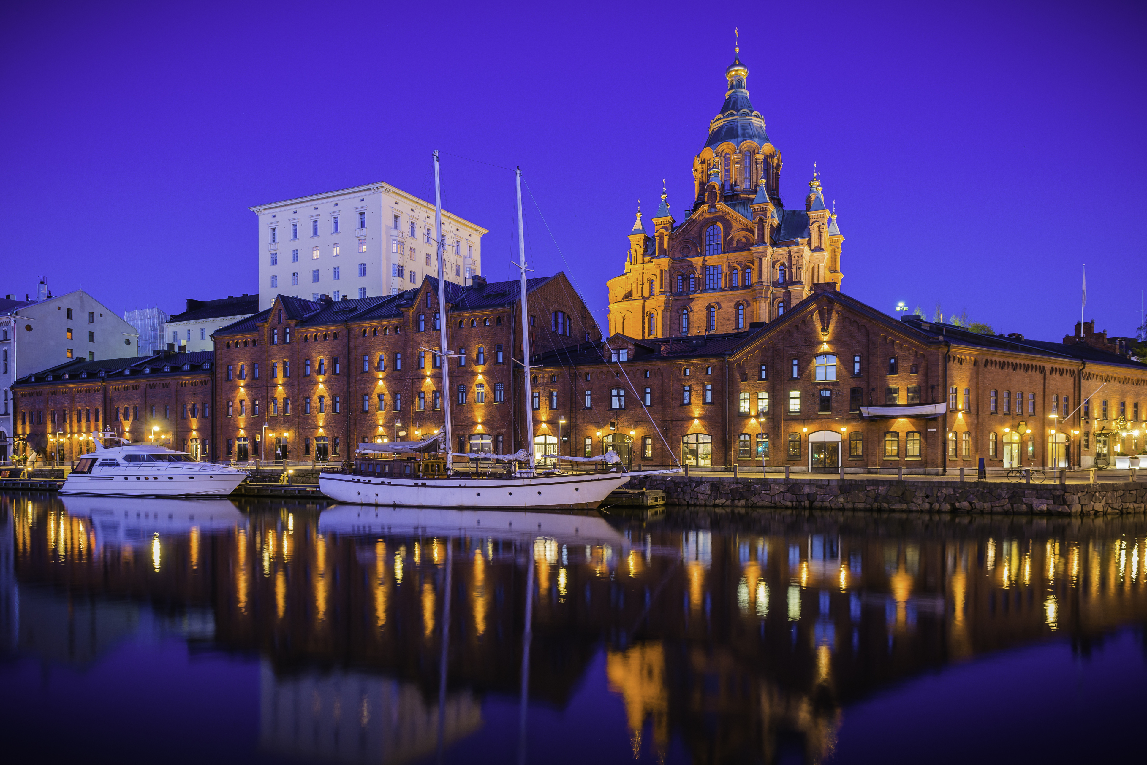 Helsinki Uspenski Cathedral reflecting in illuminated marina tranquil waterfront Finland 