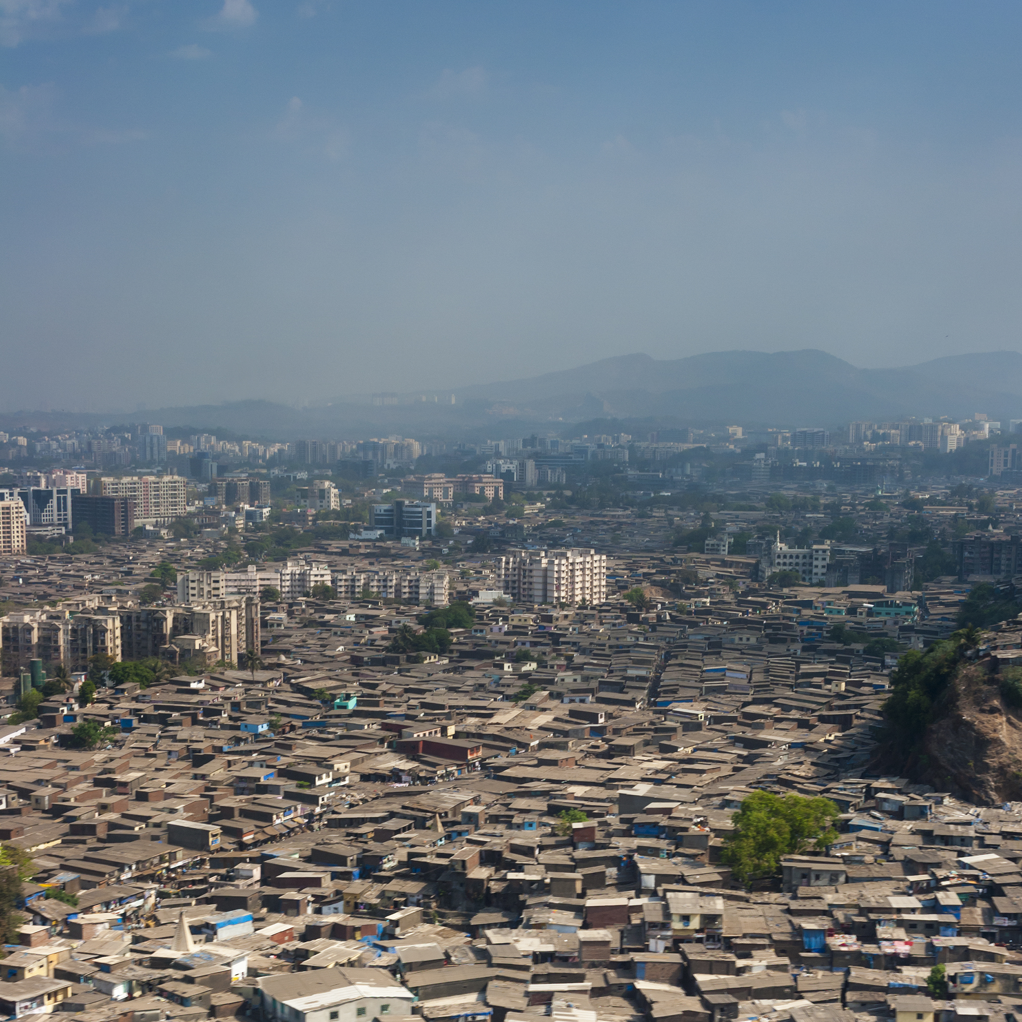 The slums of Mumbai, seen from the air, fill every gap between larger residential buildings and offices