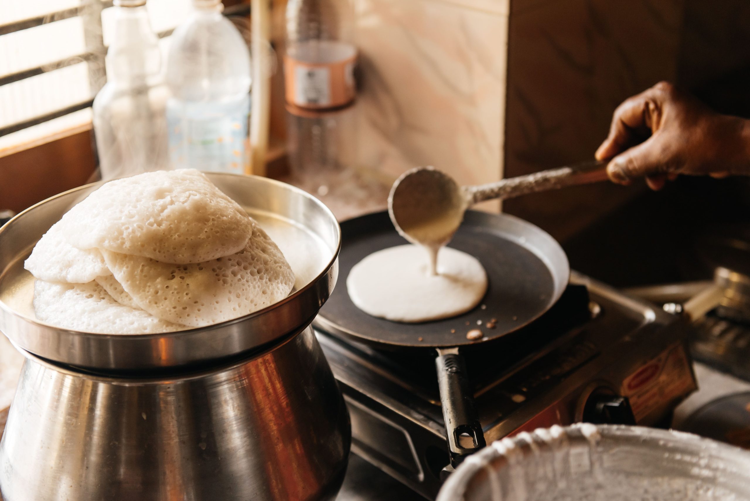 man cooking pancake on traditional stovetop