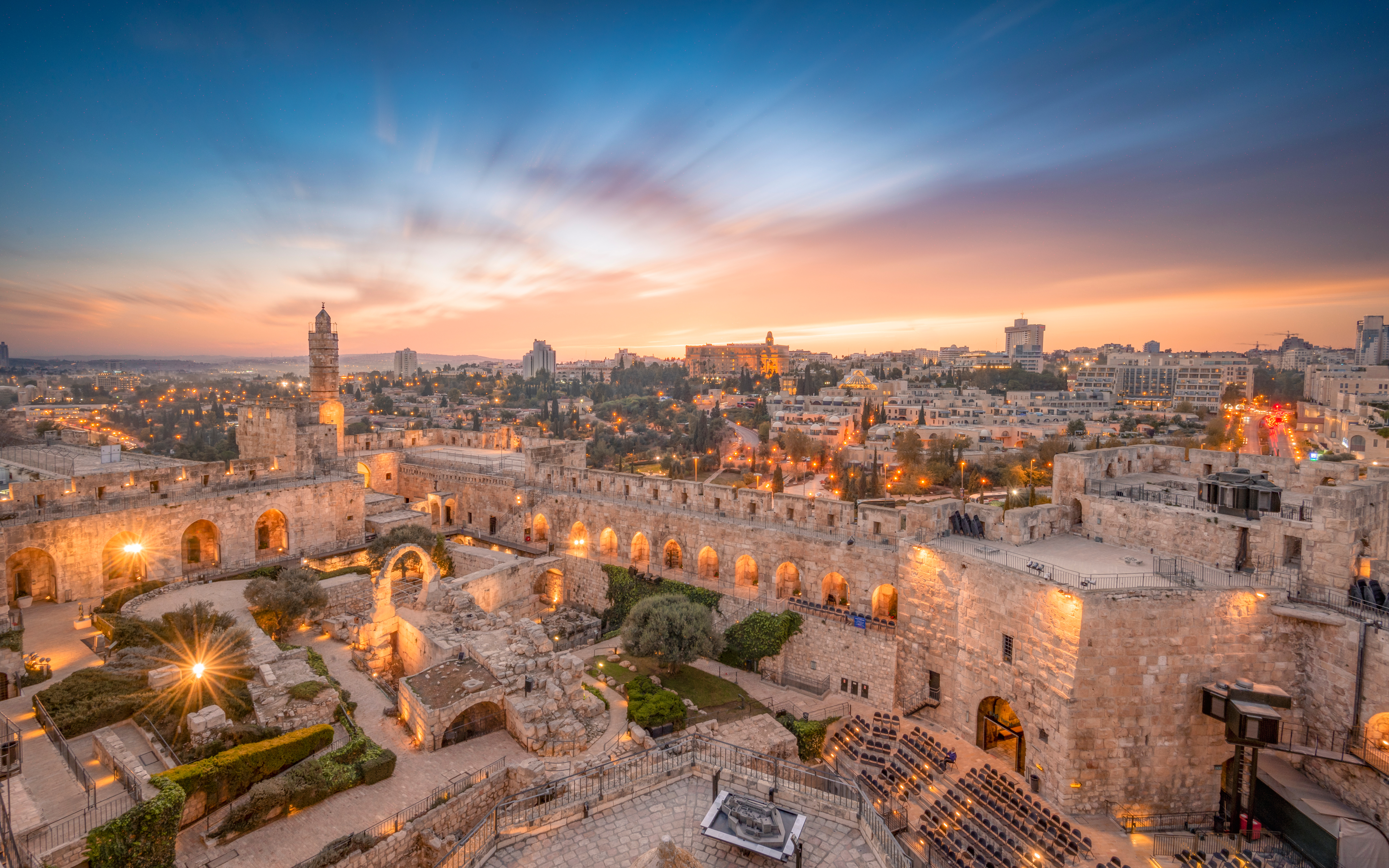 ruins and gardens set against a backdrop of a desert city