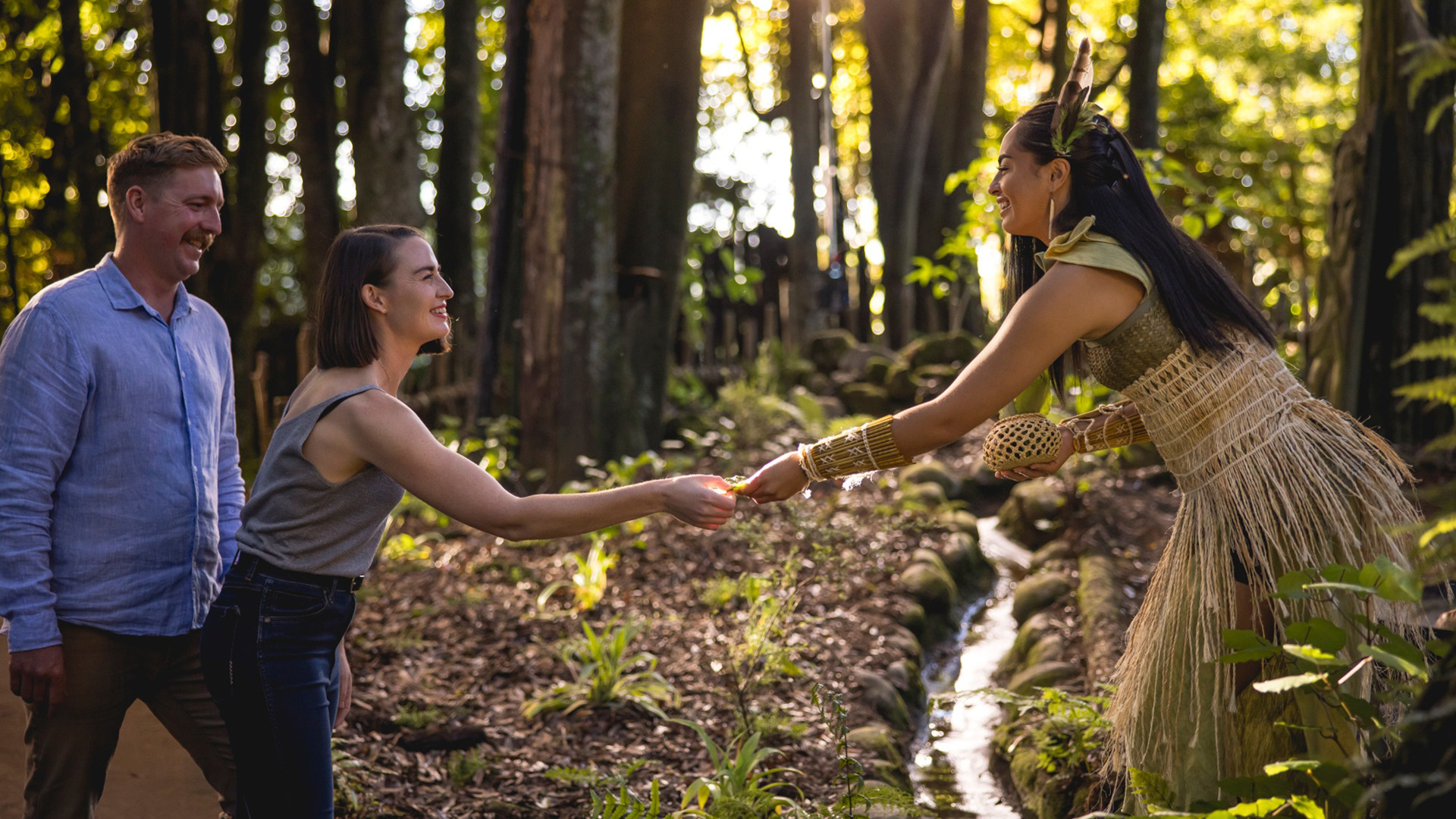 tourists meeting a Maori women in traditional dress in the forest