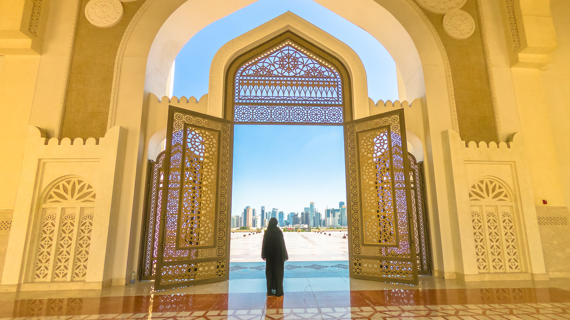 A woman standing in the doorway of the Qatar State Grand Mosque