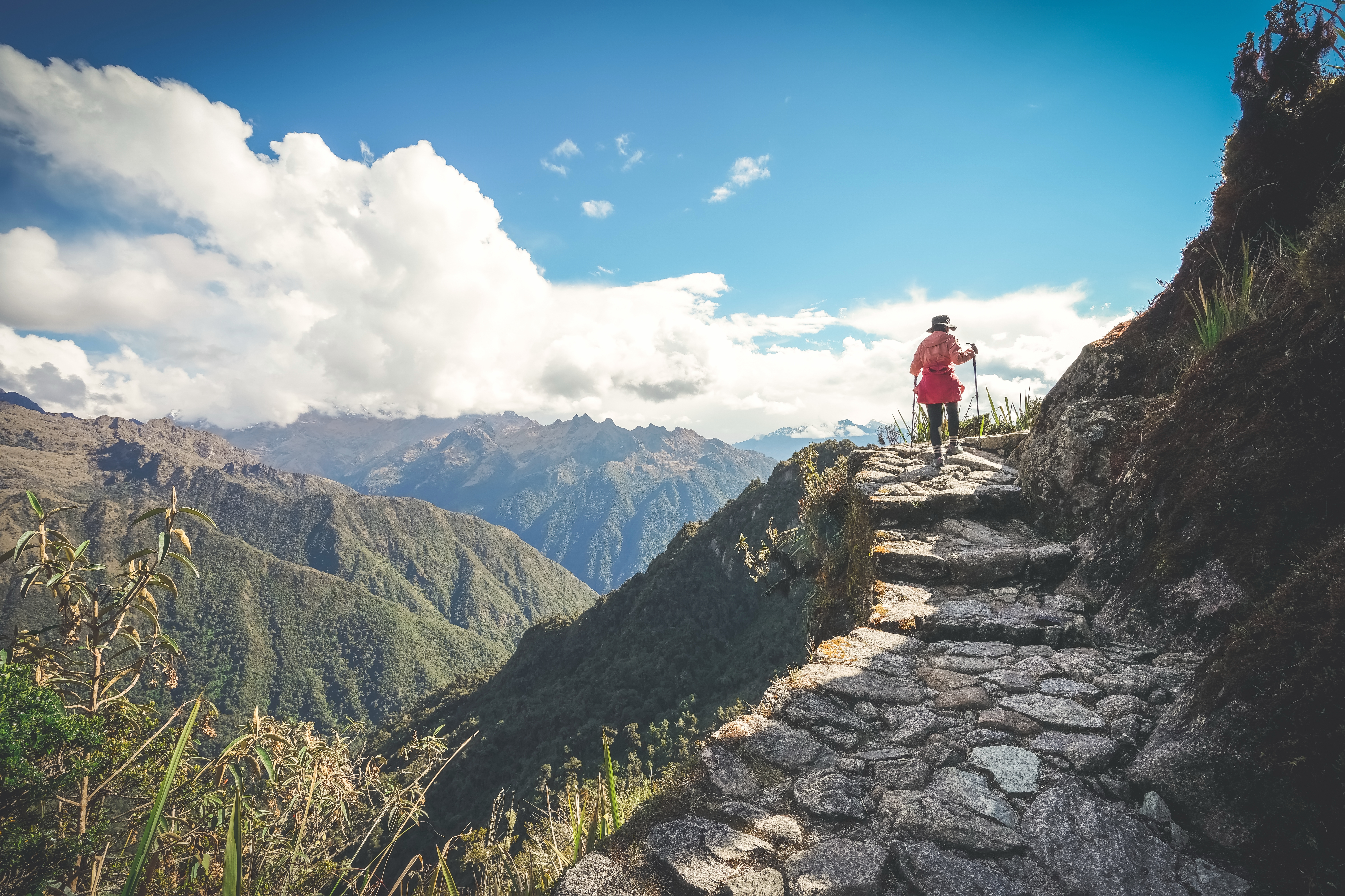 Female hiker walking towards Machu Picchu on the famous Inca Trail, Sacred Valley, Peru