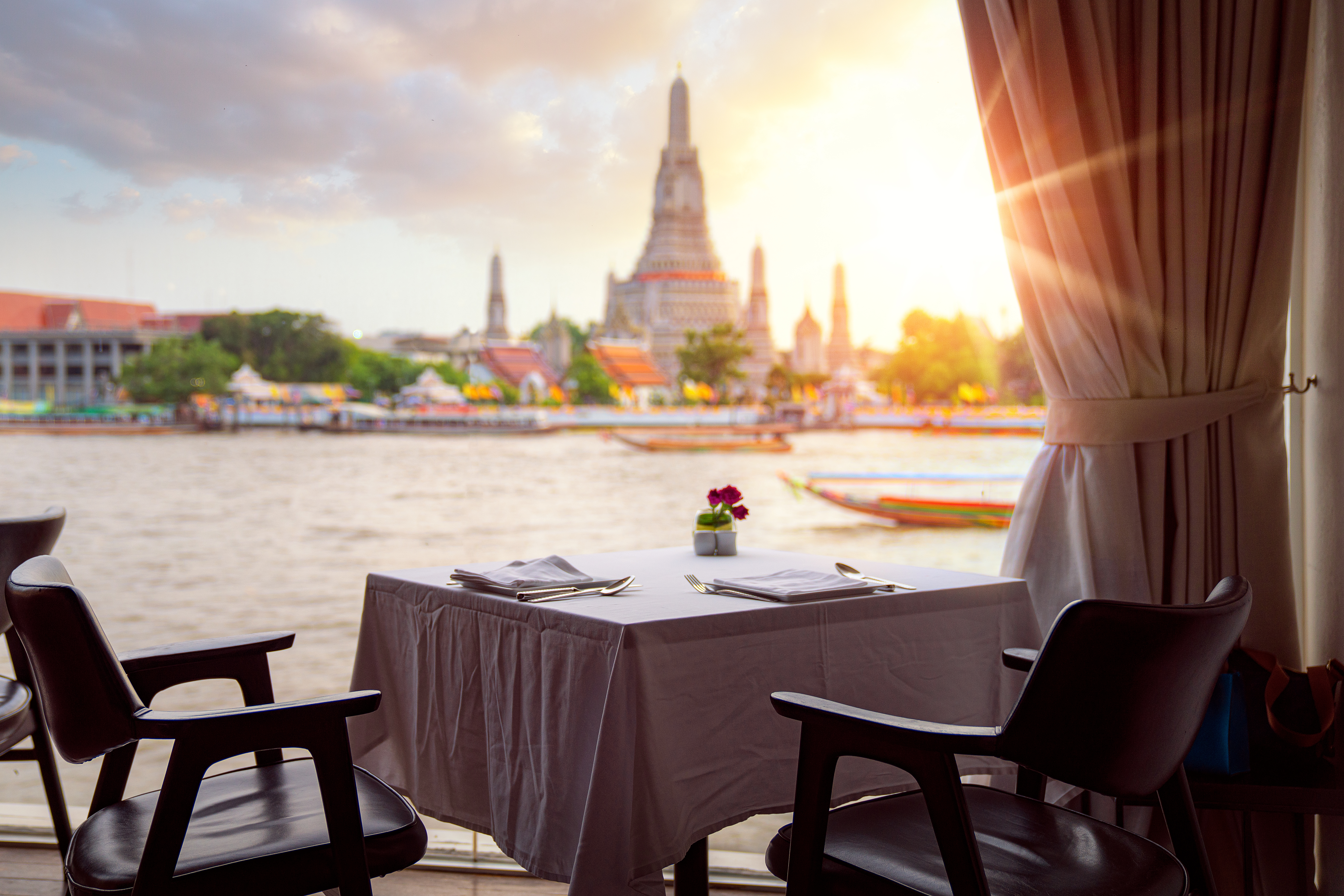 View of Wat Arun (Temple of Dawn), from riverside bar in Bangkok, Thailand