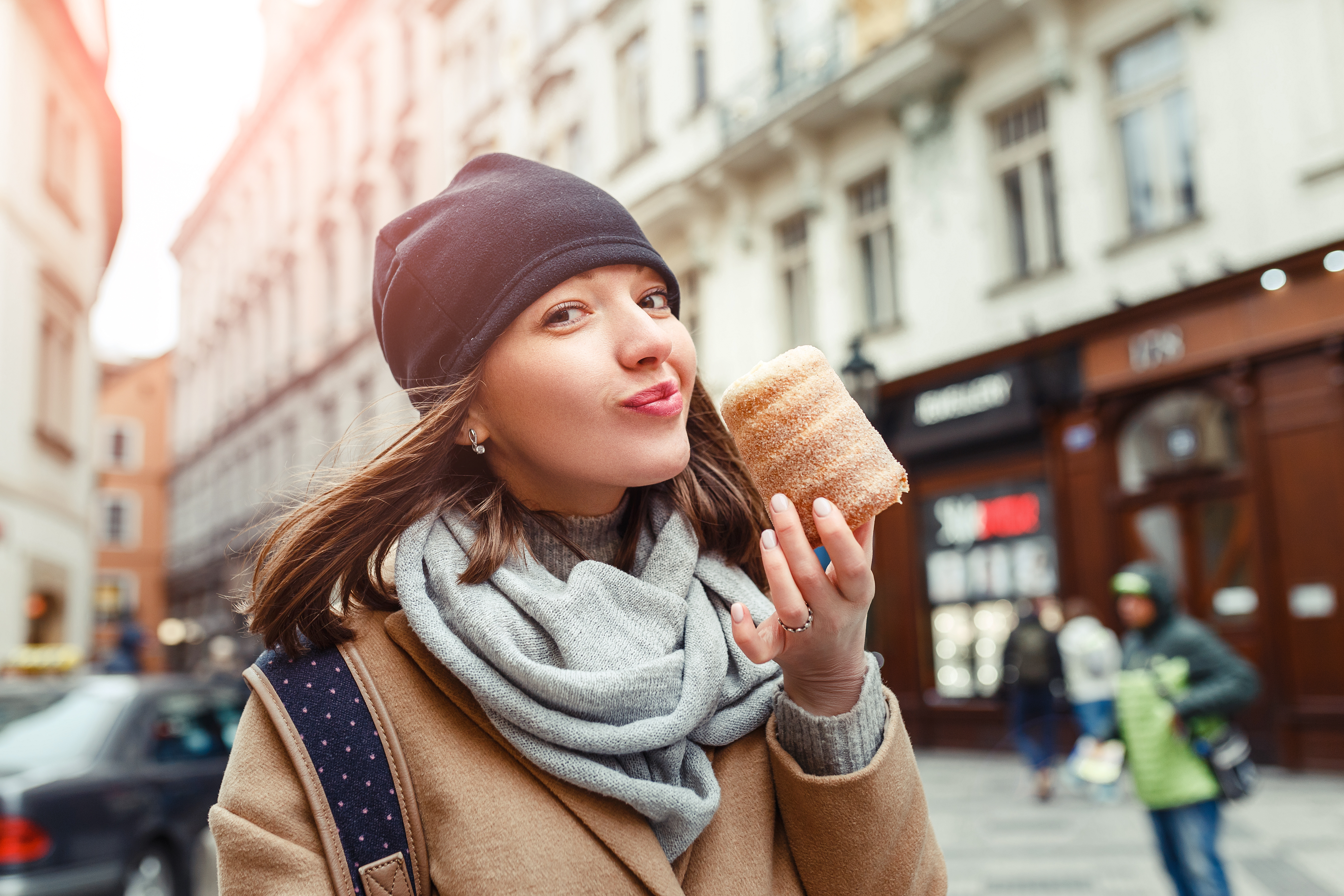 Woman eats trdelnik at a street market in Prague, Czech Republic