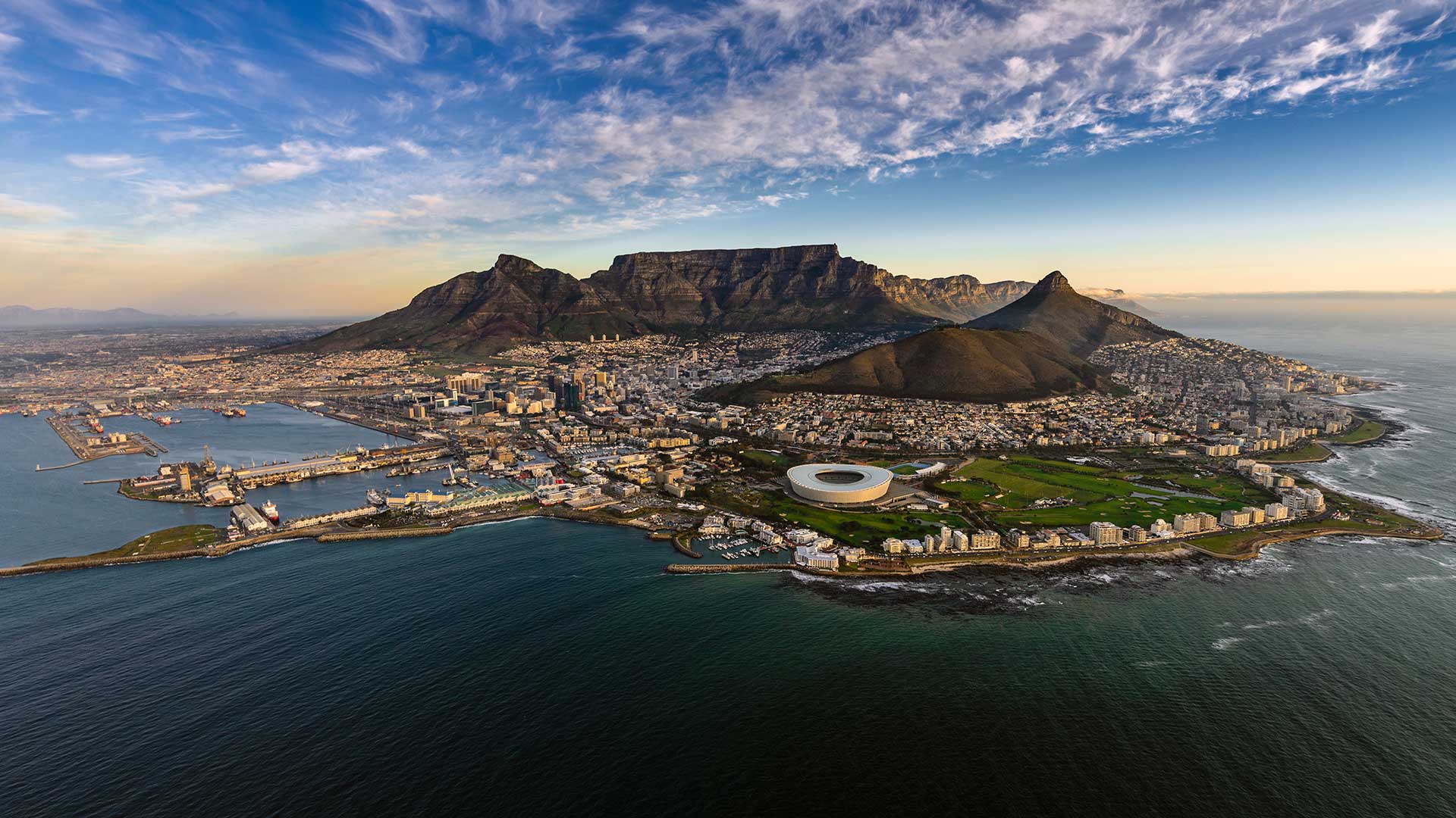 view of mountain on coastline with city beneath