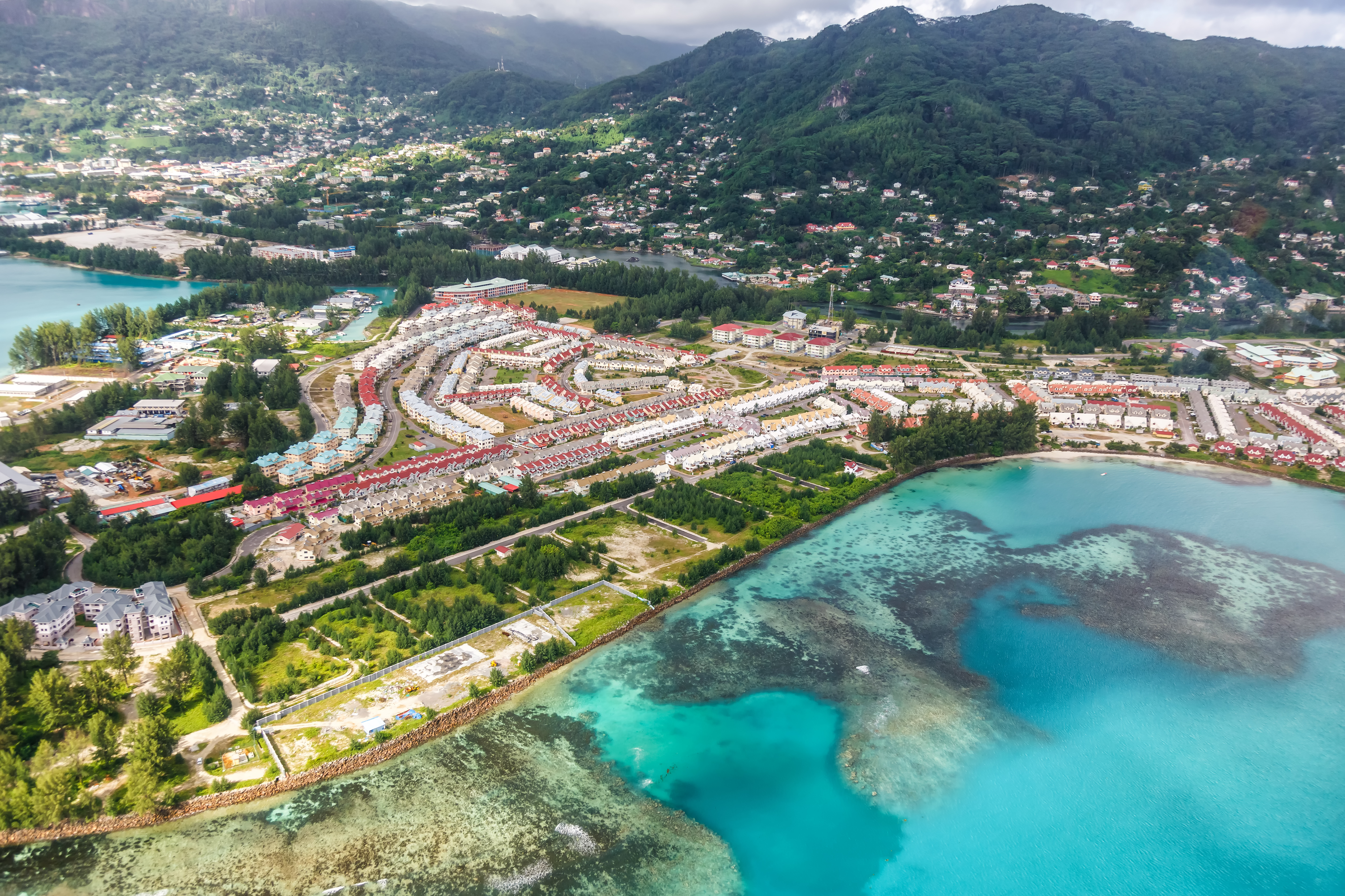 Aerial photo of neighbourhood, coastline and mountains in the background
