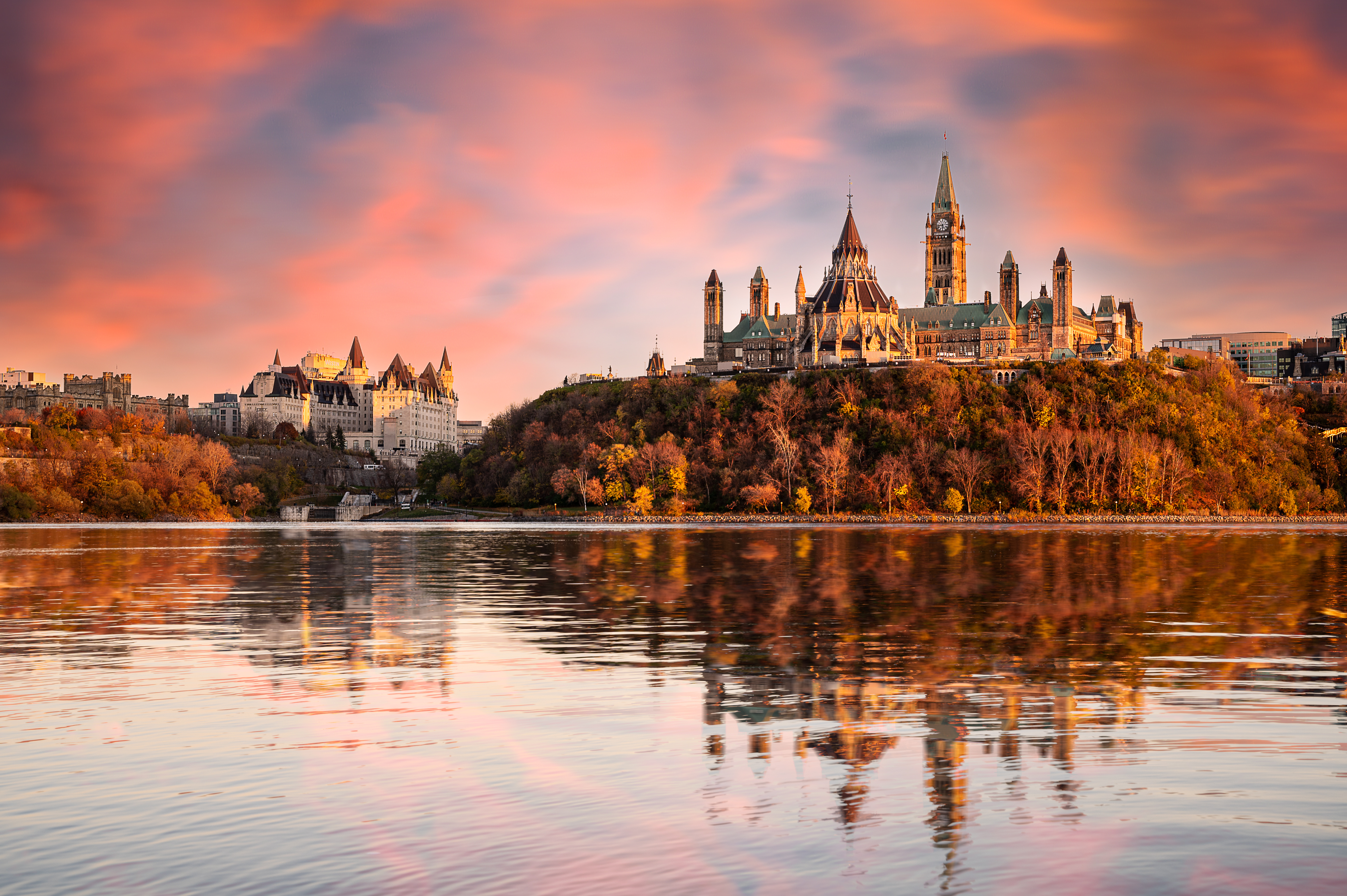 Parliament Hill and the Chateau Laurier alongside the Ottawa River at sunset