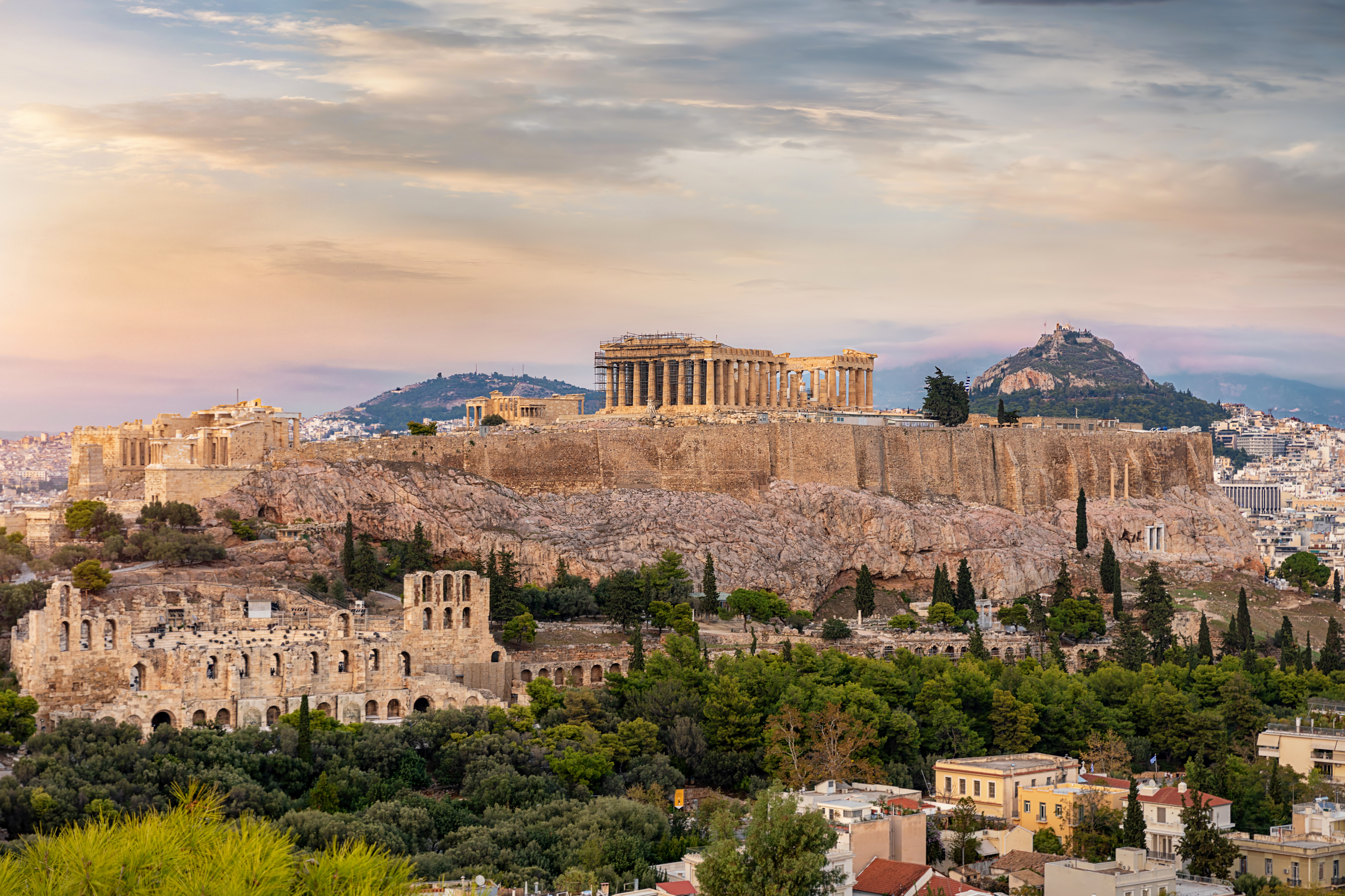 View to the Acropolis of Athens on top of the old town Plaka during a cloudy summer sunset, Greece