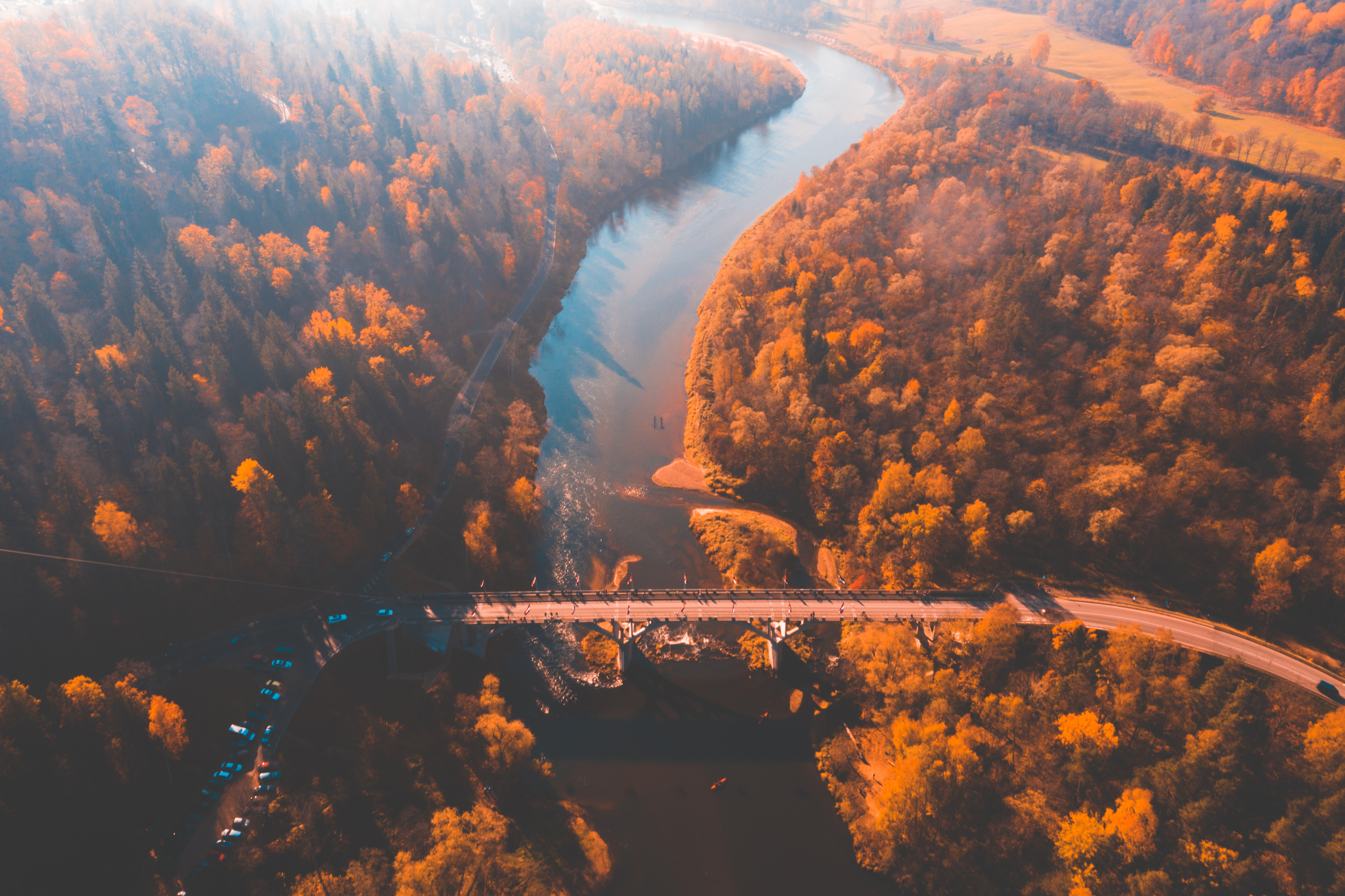 Aerial morning view of the golden autumn in Sigulda, Latvia. Gauja river bridge, cable car and golden forest.
