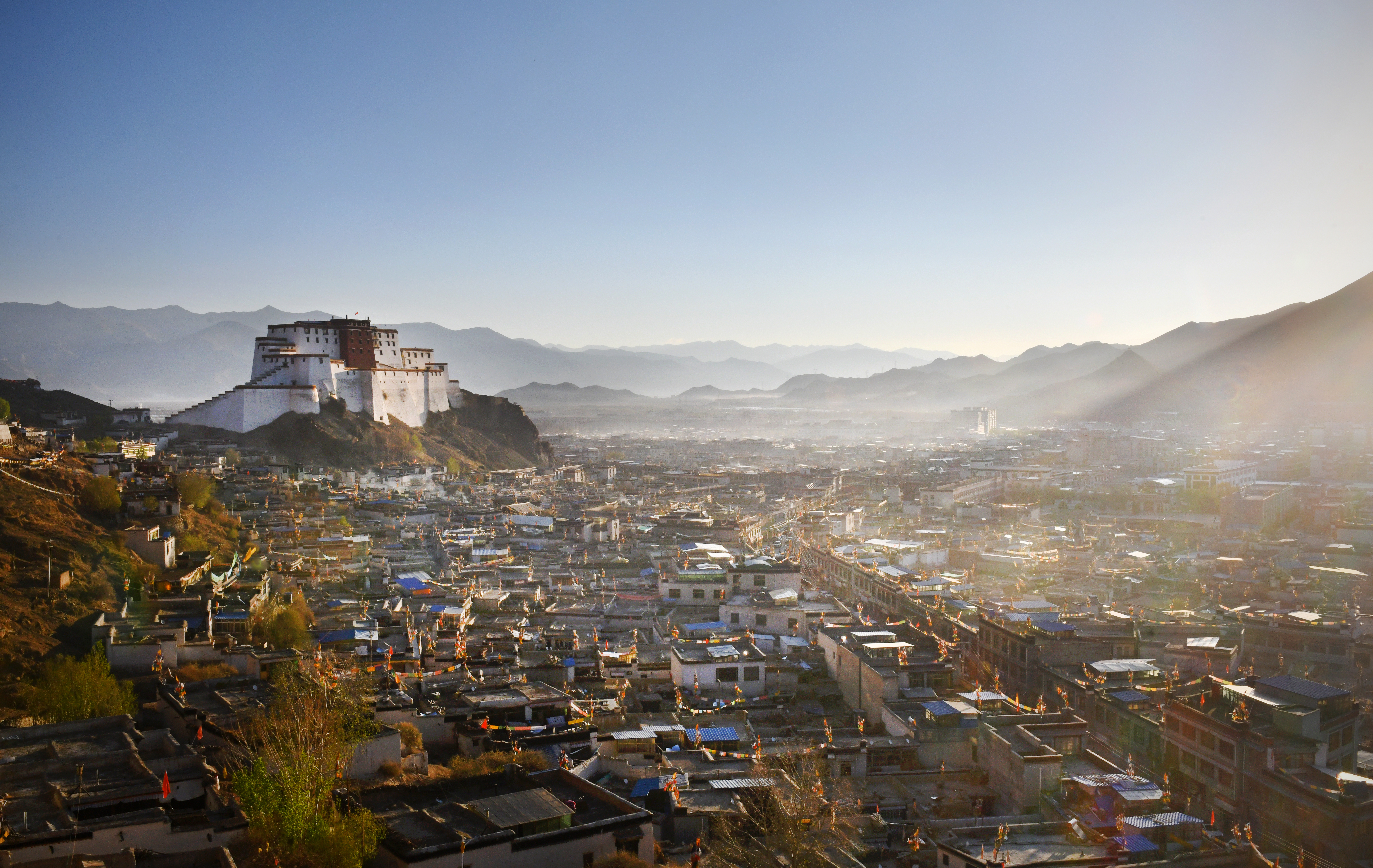 Cityscape of Tibet's second largest city Shigatse - dominated by the Dzong and distant Himalayan mountains Samzhubzê District