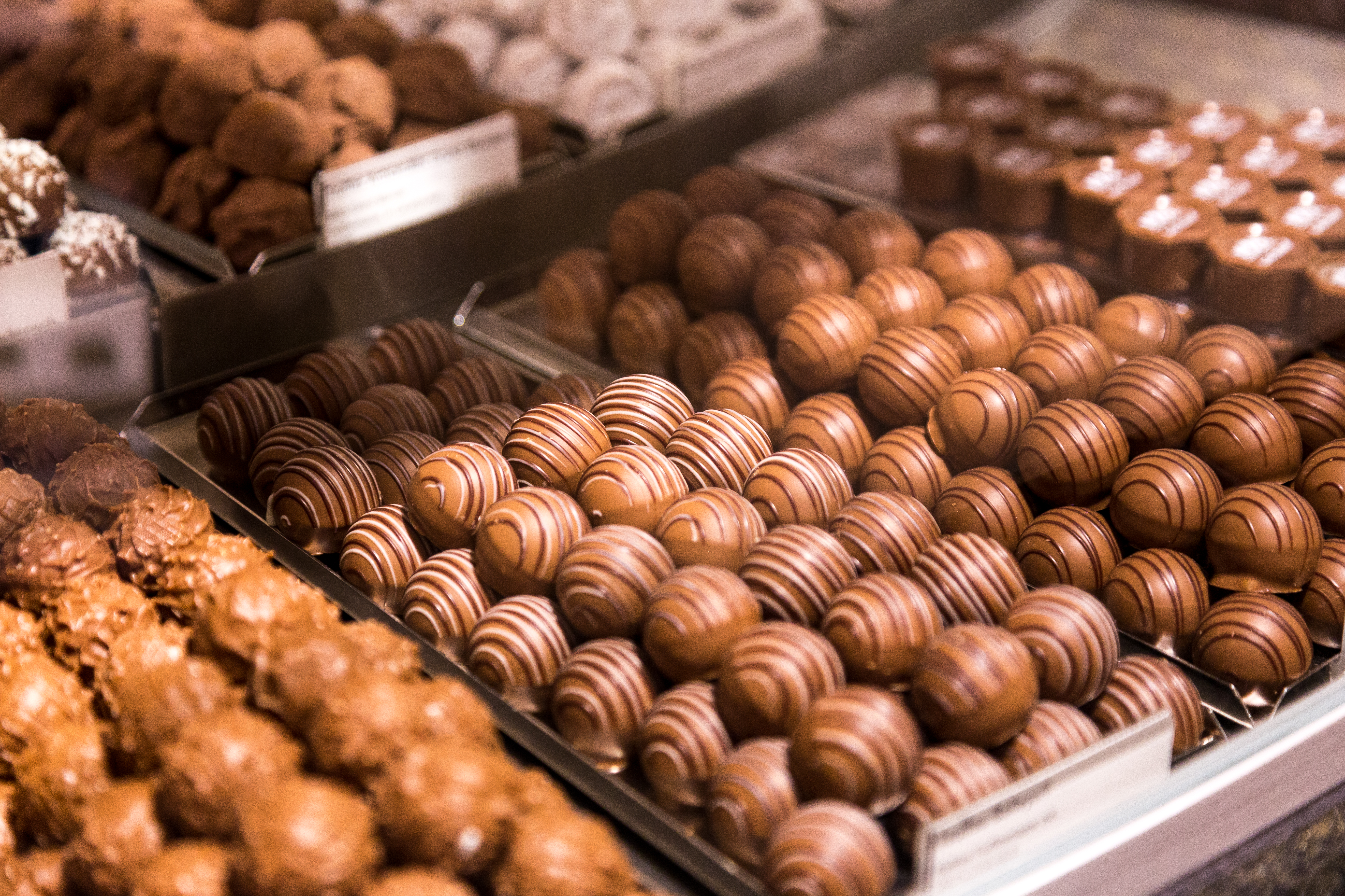 Depicting a selection of fresh Swiss chocolates and truffles on display inside a Swiss chocolate store