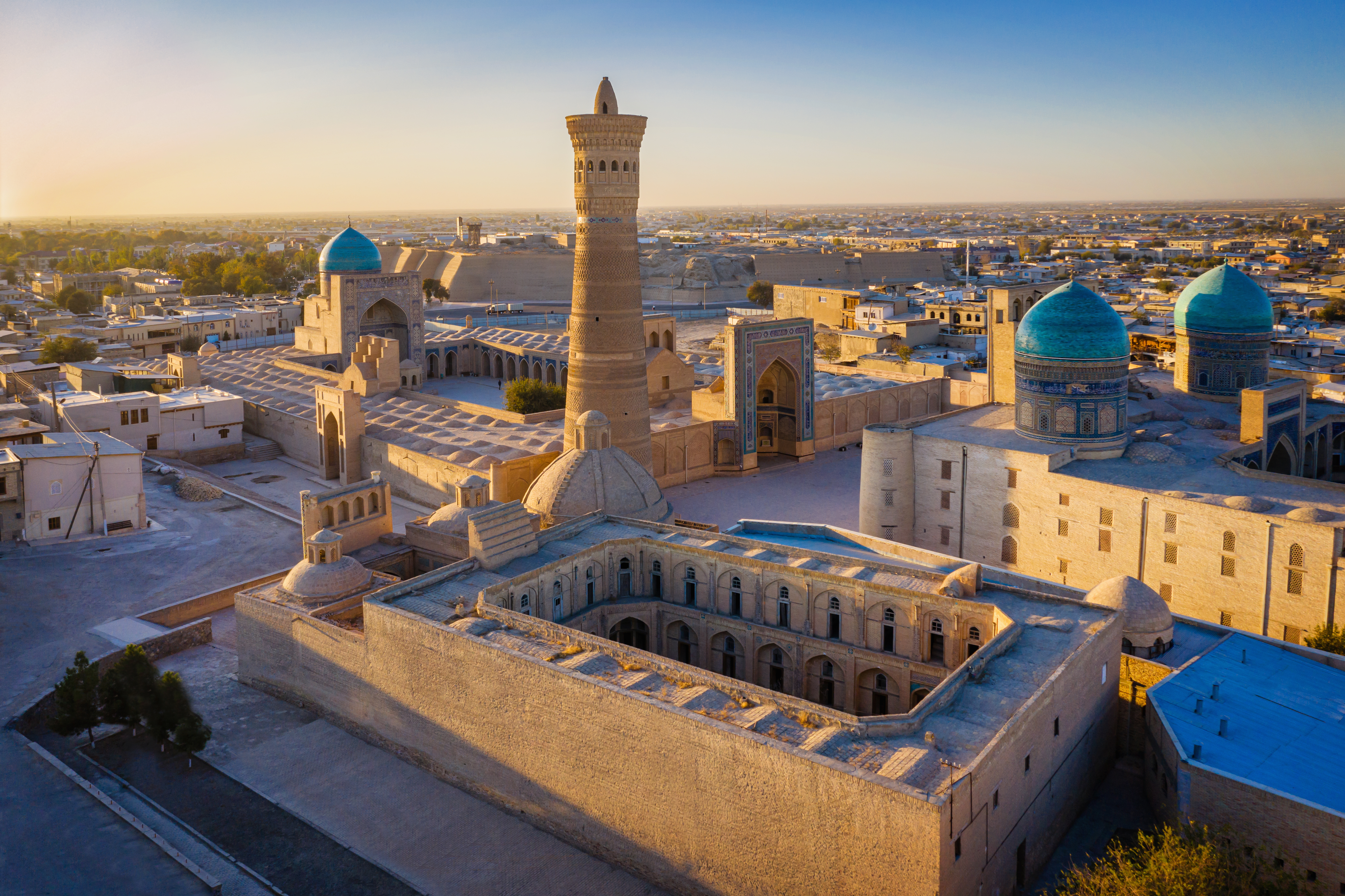 Sunset over the famous Kalyan Poi Kalon Minaret, Poi Kalan or Po-i-Kalyan and Mir Arab Madrasah in the center of the old town of Bukhara