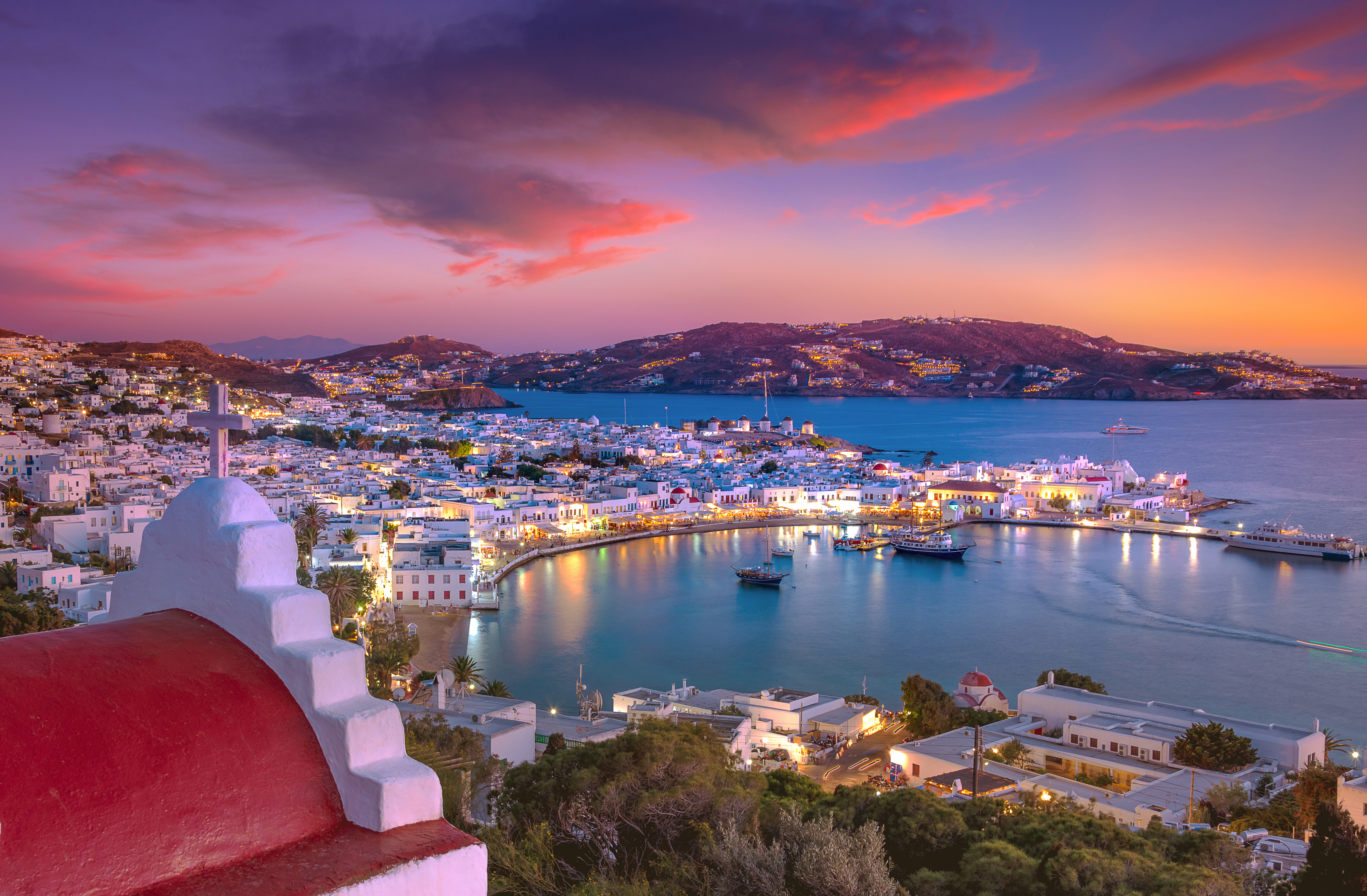 Mykonos port with boats and windmills at evening