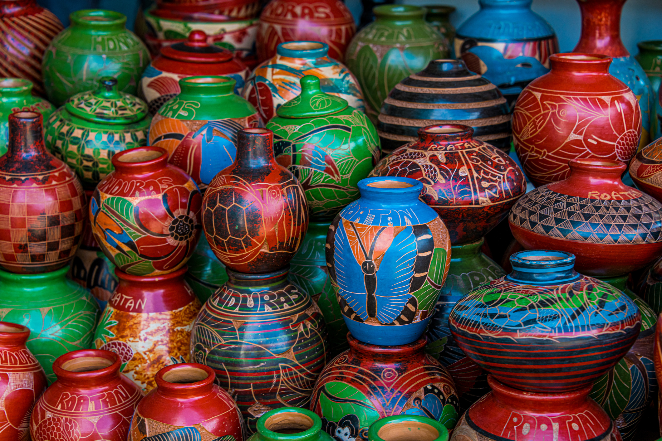 A colorful display of intricately painted ceramic pots in various patterns and designs.