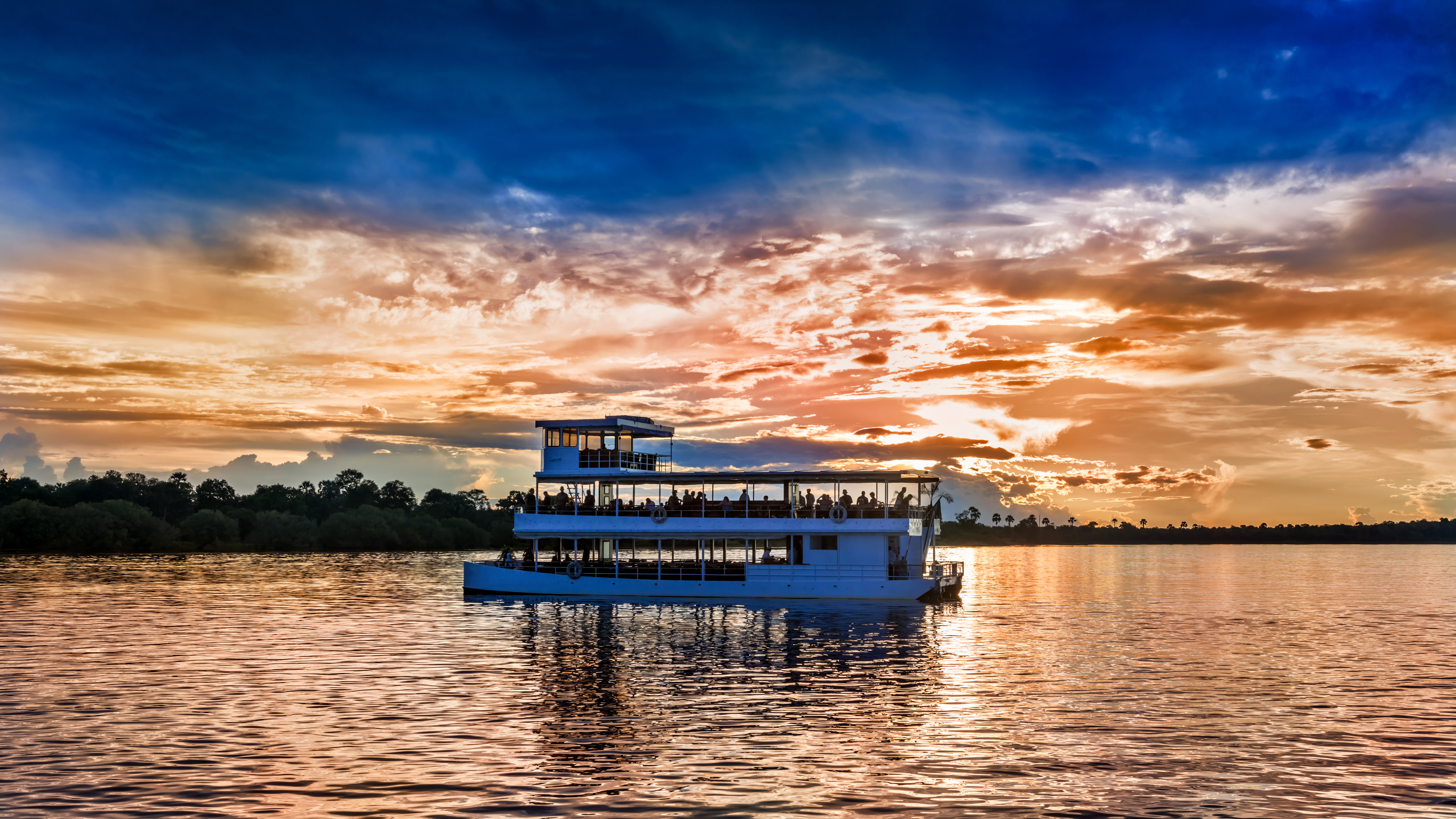 Picturesque sunset landscape with the riverboat at Zambezi river