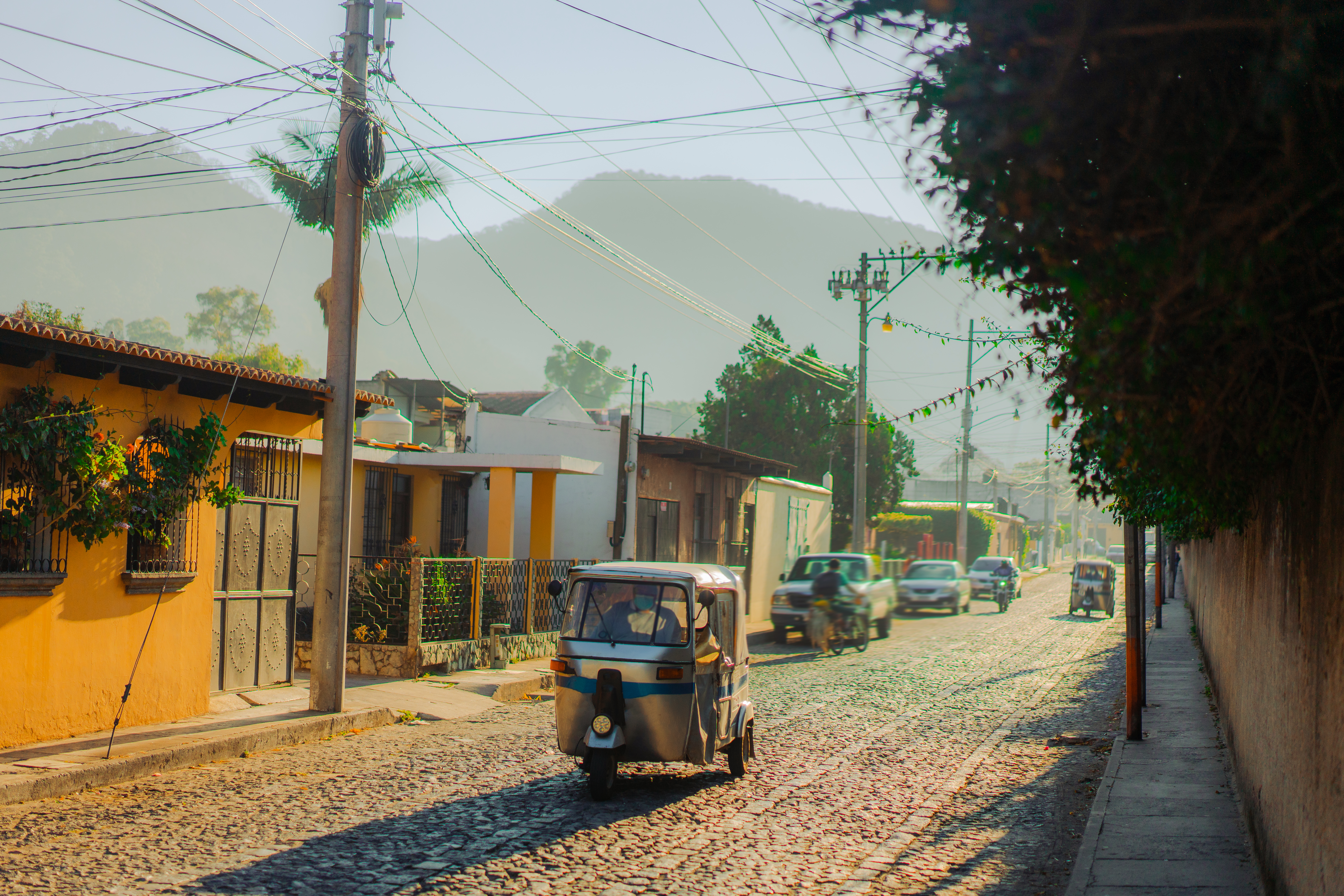 Tuk-tuk three wheeled vehicle driving along historical street in Guatemala