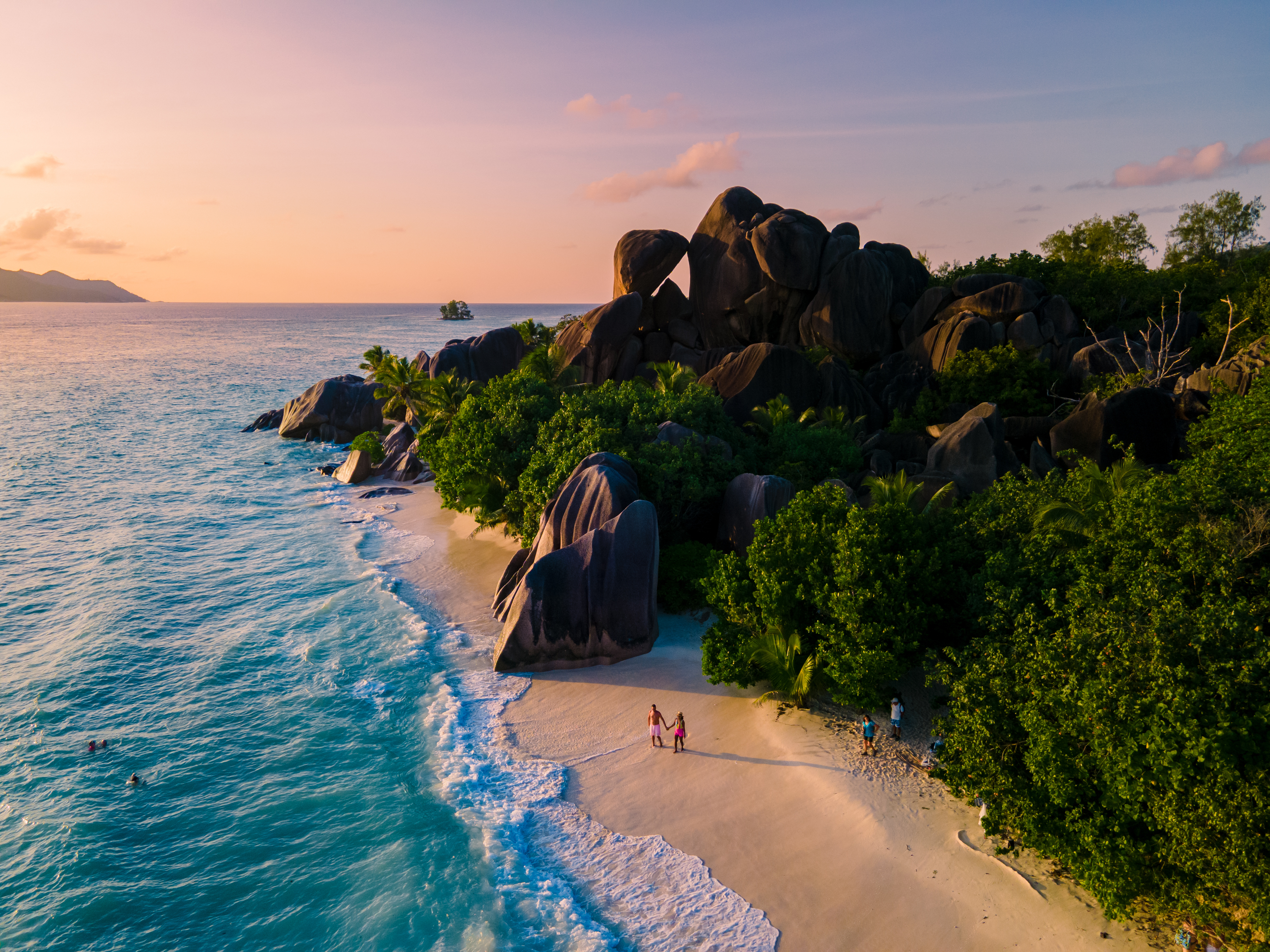 Anse Source d'Argent, La Digue Seychelles, young couple men and woman on a tropical beach during a luxury vacation in the Seychelles. 