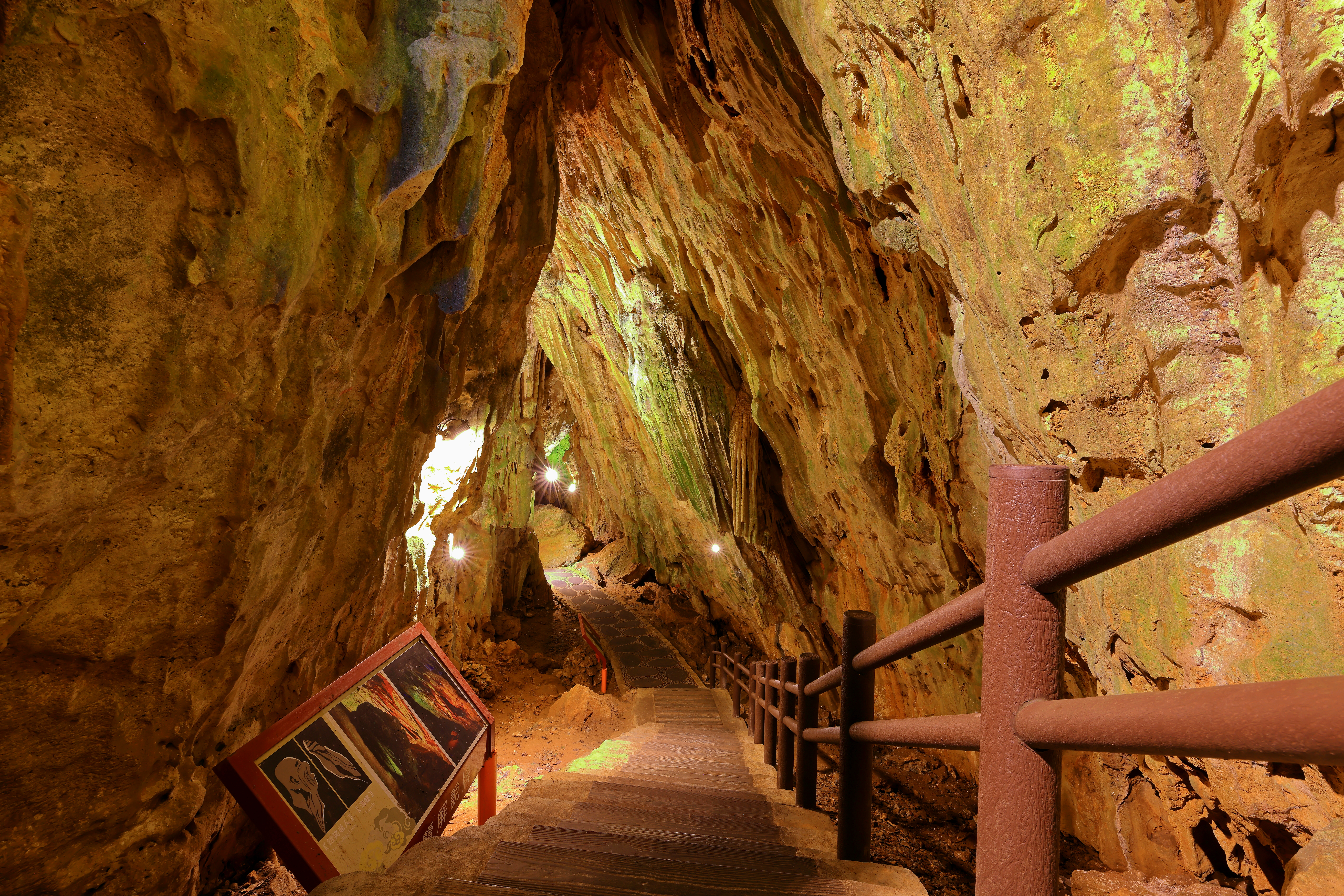 Stairs descend underneath natural rock and caves