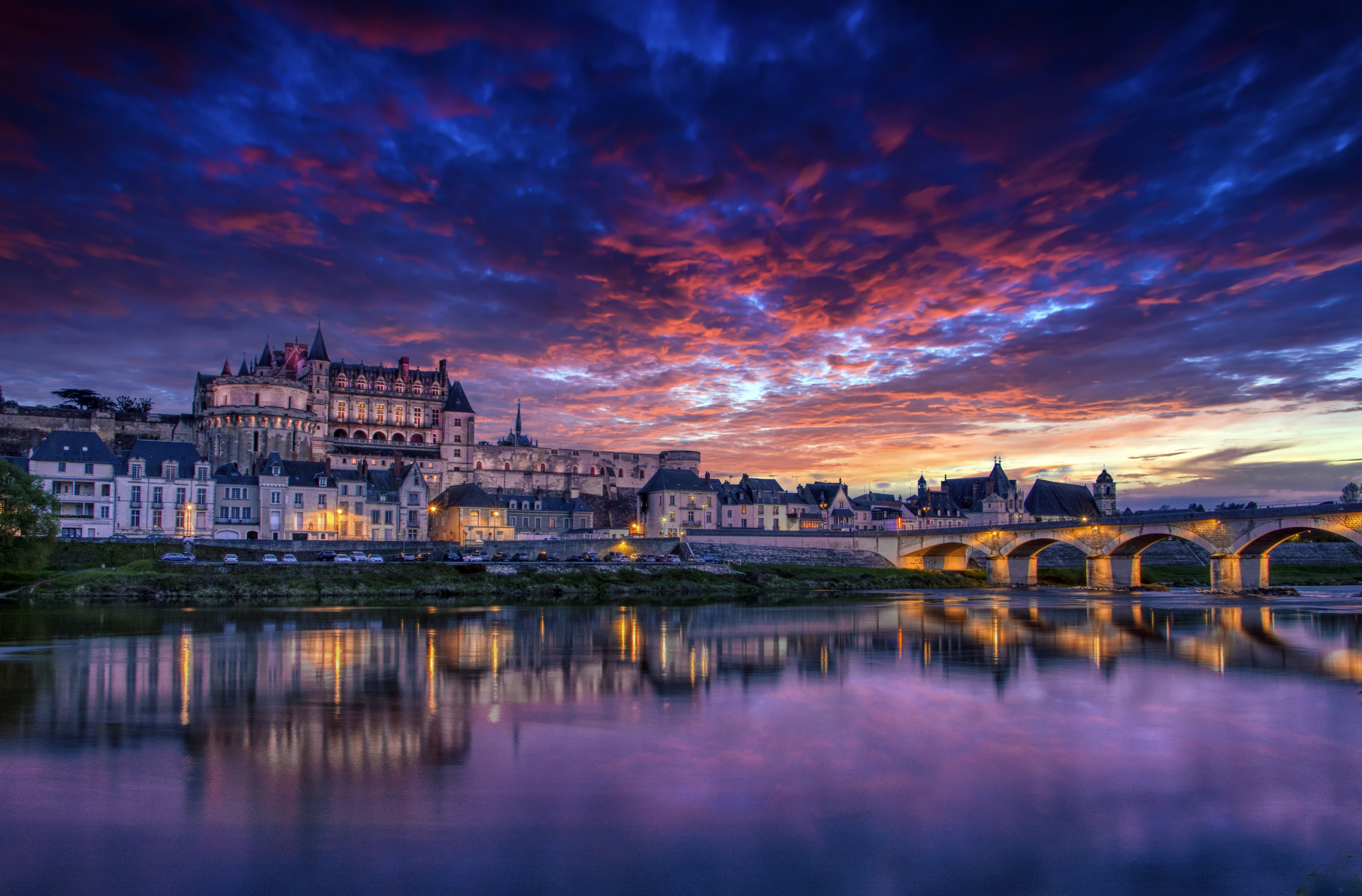 The royal chateau and ancient bridge with a vivid sunset in the background